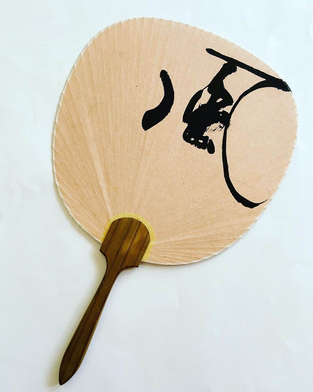 おおたうにのインスタグラム：「書家、金敷駸房さん @shimbo.k の制作現場を見学させていただきました✨  何本もの筆を重ねて持ち、一息で書かれる文字は絵画に近く、「書く」というより「描く」が似合う。 筆たちが生み出す偶然性を愉しめるのは、ひと文字ひと文字を完全に理解しているからなのだなあと、ほぼ同い年の方の内包する宇宙に、感動したり嫉妬したり。  実際の現場は、チャーミングで素敵なお弟子さんたちと和気藹々、お菓子食べたりお喋りしたり、ほのぼの楽しい空間でした☺️💕  だが…  遠い‼️‼️ 東京は広かったぜ。 （絵描いていいよと言われた団扇、私の絵なんかで汚してなるものかとそのままいただいた。ねーこれ素敵すぎない🥺✨？） #金敷駸房 #書家 #アトリエ見学 #art  #また行きたい #遠いけど」