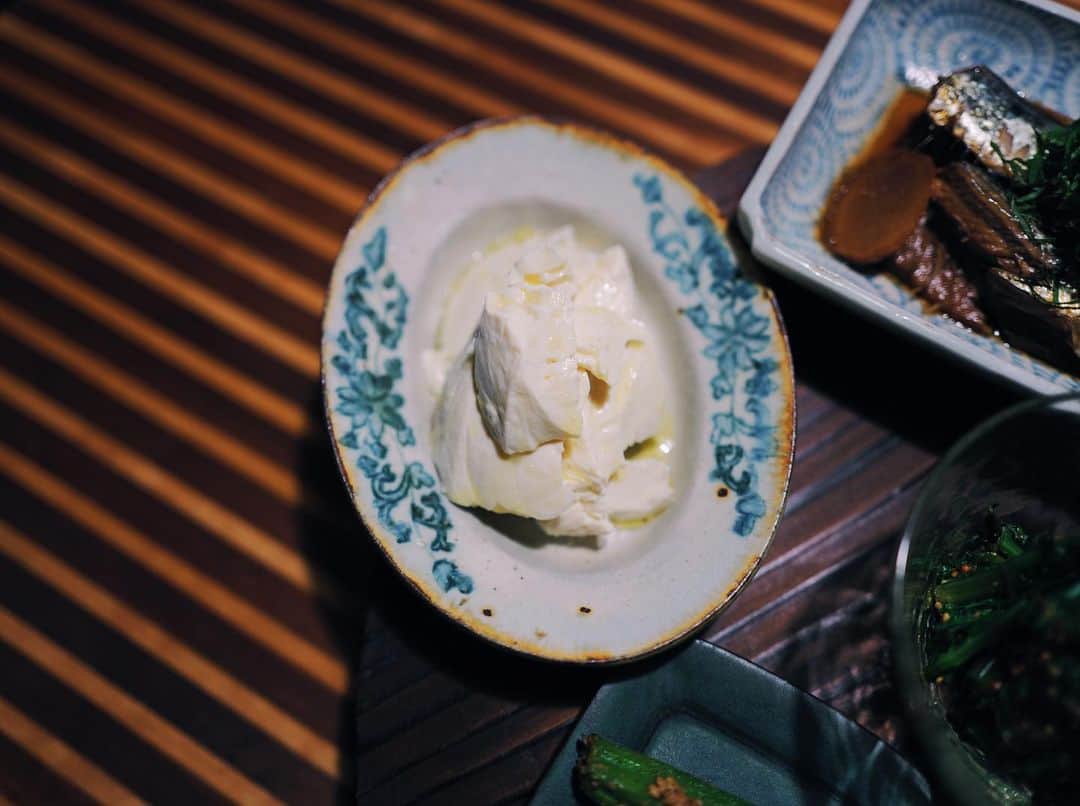 高山都さんのインスタグラム写真 - (高山都Instagram)「色々少しずつ食べたい、あっさりおばんざいスタイルは、わたしのひとりご飯の定番。 昨日は #吉川和人 さんの木のプレートにのせて。  イワシの梅煮 しっとり鶏肉の棒棒鶏　ピーナッツゴマだれで 春菊のハニーマスタード醤油和え 洋風冷や奴 オクラの胡麻和え  注目は冷や奴です。 普通のお豆腐よりも、わたしはお豆腐はしっかり水切りをし、ねっとりと味が濃くなったお豆腐が大好きで、買ってきた日に重石を乗せてしておくことが最近は多いです。  昨日は、岩塩と美味しいオリーブオイルで。 調味料すこしでも、お豆腐の水が抜けてることで満足度大。  水切り豆腐作っておくと、薄く切ったり、アイスクリームみたいに大きめのスプーンですくってみたり、崩して練って白和えにしたり。 可能性めっちゃ広がるのです。  今週の家ごはんで、だいぶ旅の塩抜きが出来た気がしてる。  #みやれゴハン」6月2日 16時33分 - miyare38