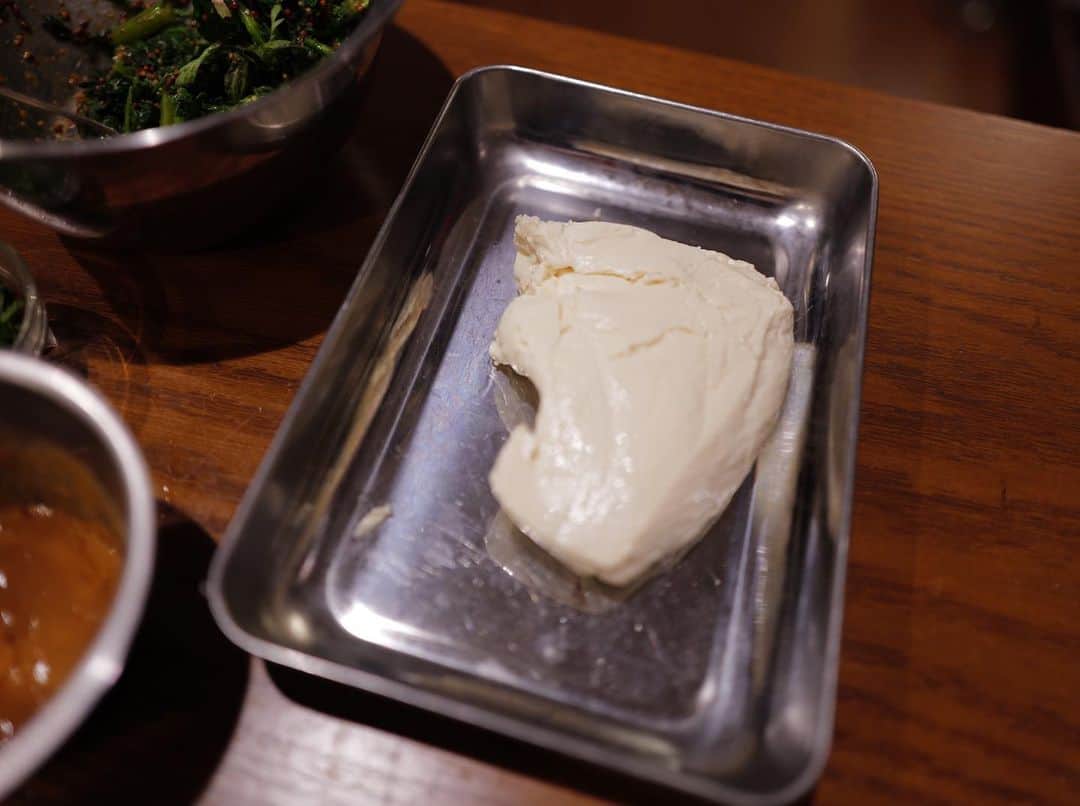 高山都さんのインスタグラム写真 - (高山都Instagram)「色々少しずつ食べたい、あっさりおばんざいスタイルは、わたしのひとりご飯の定番。 昨日は #吉川和人 さんの木のプレートにのせて。  イワシの梅煮 しっとり鶏肉の棒棒鶏　ピーナッツゴマだれで 春菊のハニーマスタード醤油和え 洋風冷や奴 オクラの胡麻和え  注目は冷や奴です。 普通のお豆腐よりも、わたしはお豆腐はしっかり水切りをし、ねっとりと味が濃くなったお豆腐が大好きで、買ってきた日に重石を乗せてしておくことが最近は多いです。  昨日は、岩塩と美味しいオリーブオイルで。 調味料すこしでも、お豆腐の水が抜けてることで満足度大。  水切り豆腐作っておくと、薄く切ったり、アイスクリームみたいに大きめのスプーンですくってみたり、崩して練って白和えにしたり。 可能性めっちゃ広がるのです。  今週の家ごはんで、だいぶ旅の塩抜きが出来た気がしてる。  #みやれゴハン」6月2日 16時33分 - miyare38