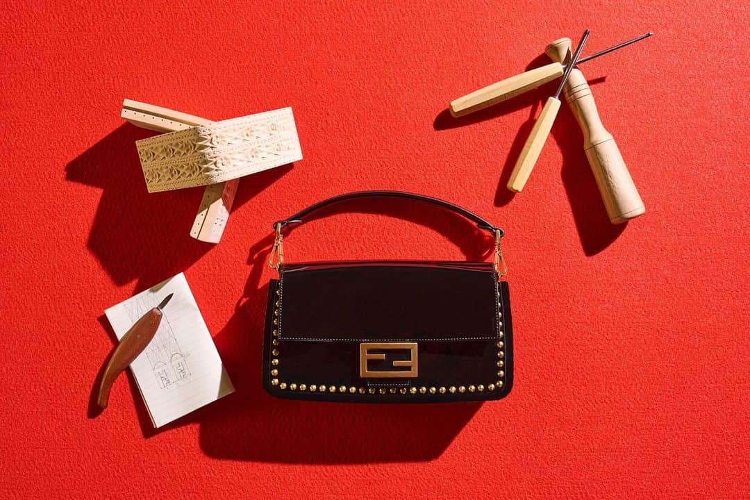 Fendiのインスタグラム：「Currently on display in Beijing through 16 June as part of the #FendiHandInHand exhibition, four new #FendiBaguette iterations represent regional craftsmanship traditions from across Italy.  The participating artisans were personally selected by Silvia Venturini Fendi.  From the Aosta Valley, woodwork artisan Ornella Crétaz imagined a black patent leather bag with gold studded details in a frame carved from a single piece of limewood, embellished with scalloped, diamond, and floral details, and engraved with FF motifs.  For Campania, Real Seta Italian Silk Fabrics created a custom silk FF logo base and applied a delicate, leafy floral pattern from their family archives in a juxtaposition of organic and geometric designs.」