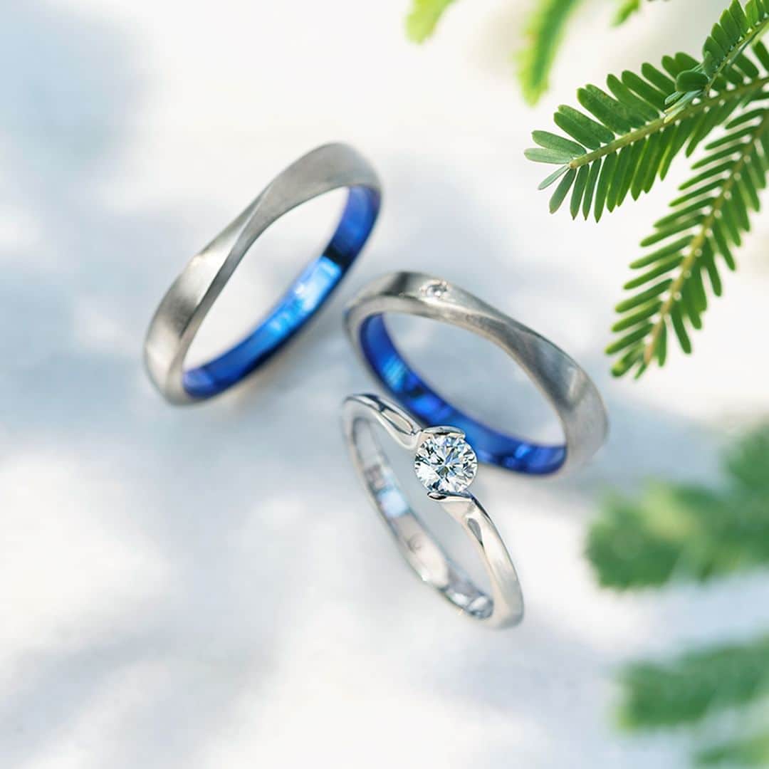 のインスタグラム：「#結婚指輪SORA 【TILLEUL-ティユール-】 菩提樹から名付けられた婚約指輪💍*  夏に淡黄色の花を咲かせる菩提樹は、 「夫婦愛」「結婚」の花言葉を持っています。  木の下で未来を誓い合う二人をイメージして、 お互いの手を添えてダイヤモンドを 抱えているようなアームが特徴。  ダイヤモンドの表面を隠さないSORA独自の石留め方法 #ノッチグリップセッティング により、 ダイヤモンドをより美しく輝かせます。  細身で石座を低く抑えたシンプルなデザインなので、 毎日でも身につけていたいほどのつけ心地を叶えました。  ◤ティユール 取扱店◢  ・SORA表参道本店 ・SORA札幌店 ・一部の全国の取扱店 ・SORA公式オンラインショップ >>>https://www.sora-w.com/online/  - - - - - - - - - - - - - - - - - - - -   🟩LINEでもデザインのご相談が可能です >>>「SORA」と検索！  公式アカウントをお友だち登録して メッセージを送ってください  SORA表参道本店のデザイナーがご返信します💁‍♀️  - - - - - - - - - - - - - - - - - - - -   SORA公式サイトや店舗情報は アカウントTOPのURLからcheck * >>> @sora_omotesando  ぜひハッシュタグをつけて SORAの写真を投稿してください♪ >>> #結婚指輪SORA  デザイナー、クリエイターが皆さんの投稿を拝見し 毎日パワーをいただいています🌿  - - - - - - - - - - - - - - - - - - - -   #表参道 #結婚指輪 #婚約指輪 #ペアリング #金属アレルギー対応リング #婚約指輪オーダーメイド  #婚約指輪探し #婚約指輪と重ね付け #プロポーズリング #ダイヤモンドリング #重ね付け #セットリング #2023wedding #プレ花嫁準備」