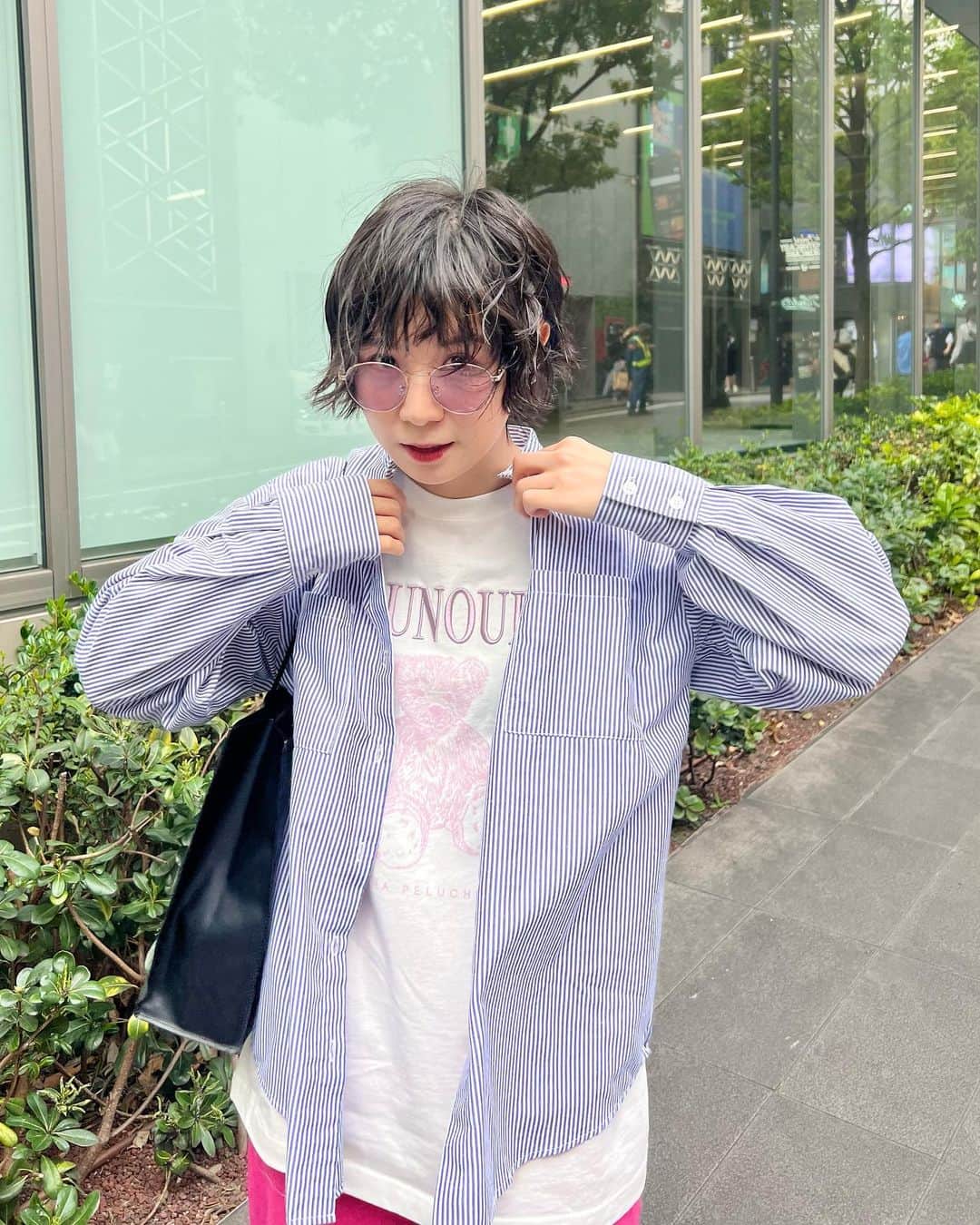 光永のインスタグラム：「ピンクたくさんだけどメンズライクにまとめたコーデ🧸🌷 Tシャツの文字が立体的で好き。 大きめストライプシャツは何枚あったって良い。 暑くなるとこれくらい元気な色のボトム履きたくなる。 紙袋みたいなレザーみたいなバッグはカジュアルだけど大人っぽくまとまるし、合わせやすいからめちゃくちゃ使ってる。 靴は黒だと重いし、白だとトップス主役にならないし、他色だとうるさいのでグレーが絶妙に遊んでてちょうどいいです🩶 ㅤㅤㅤㅤㅤㅤㅤㅤㅤㅤㅤㅤ Tシャツ：#merryjenny シャツ：#libracue パンツ：#momentplus スニーカー：#moonstar バッグ：#kentohashiguchi  サングラス：#3coins ㅤㅤㅤㅤㅤㅤㅤㅤㅤㅤㅤㅤ #初夏コーデ #カラーパンツ #ストライプシャツコーデ #白tコーデ #メンズライクコーデ #ボーイッシュショート #ショートヘアアレンジ」