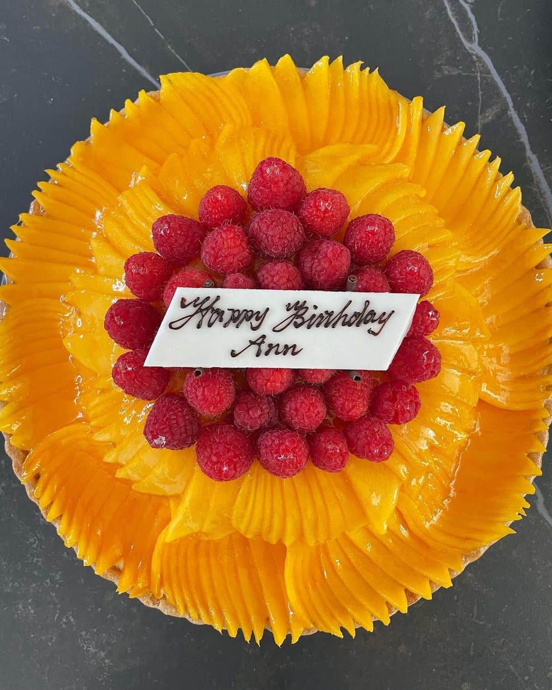 大橋菜央のインスタグラム：「Mango tart for birthday gathering🥭 . . . 今回のお誕生日会は親戚勢揃いなので 大きくてみんな大好きなマンゴーのタルトのケーキ🤤♡ @quilfaitbon_official  . 切り分ける前にAnnがラズベリーを全てたいらげてしまい 真っ黄色のタルトになってしまいました🥹 . それでもマンゴーたっぷりで美味しかったなー💕 . . . #キルフェボン #birthdaycake #mangotart」