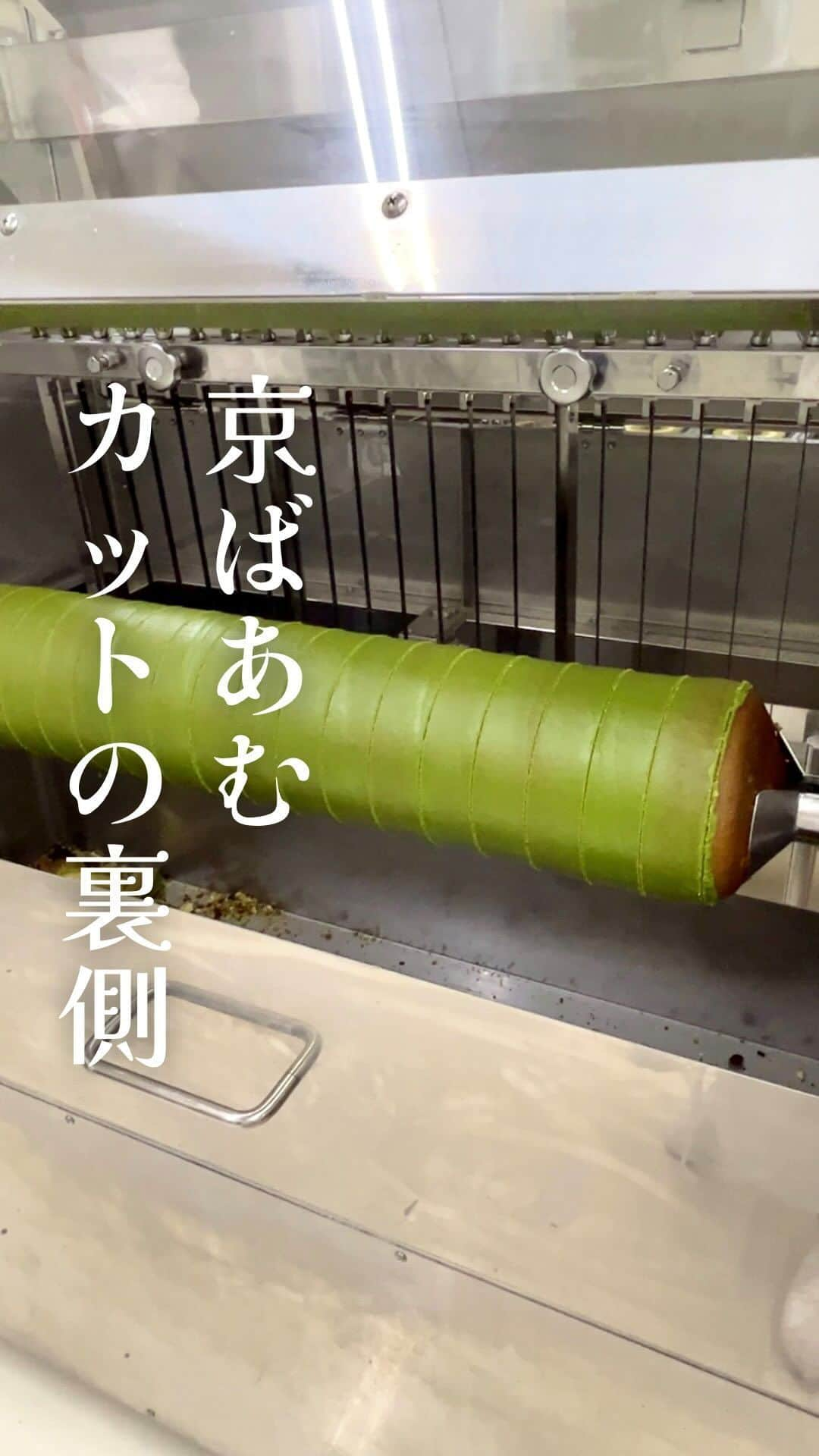 京ばあむ公式のインスタグラム：「\ もう1人の職人⁉️ カット自動機 /  以前の投稿「秘技！京ばあむカッター」 ご覧いただけましたか？👀  職人たちが京ばあむを一つ一つ 丁寧にカットしていく様子は 見入ってしまうものがあります🥺  今回は、もう1人(?)の職人‼️ "カット自動機"をご紹介します🥳✨  職人の技に負けず劣らず💪🏻 見応えあり ＆ 最後にスッキリ気持ちいい〜 自動機の様子は必見です🤩‼️🔥  ・  京ばあむを丸々１本、自動機にセット🤲🏻 あとはボタンをポチッ🔘👈🏻  京ばあむを回転させながら ノコギリのようなギザギザした刃で １本まとめて瞬時にカットしてくれます🦾  最後にスッと刃を抜きとる瞬間は 爽快感抜群〜〜っ‼️💫  なんとこの動画・・・ タイトルにもありますが 本当に「裏側」から撮影しています😳📸  自動機裏側の隙間にカメラを設置して😉  普段どのスタッフも見ることができない 特別な角度をお届けしてみました😎✨  ・  3層の断面が特徴の京ばあむにとって、 カットの美しさは非常に重要なポイントです💡  皆さまに美しい京ばあむをお届けすべく！ この自動機も日々メンテナンスを行い 進化し続けています😊  今は京ばあむのほとんどが人の手でカットされ、 カット自動機は2割程度を担当しています。  今後、自動機の活躍は人の手を 超えてくるのでしょうか…？🤔💭  京ばあむはまだまだ進化し続けます🌟  #京ばあむ #アトリエ京ばあむ #atelier京ばあむ #バームクーヘン #抹茶スイーツ #抹茶 #京都 #京都スイーツ #京都土産 #しっとり #ほわほわ #baumkuchen #kyobaum #kyoto #おやつ #カット #工場 #工場見学 #自動化」