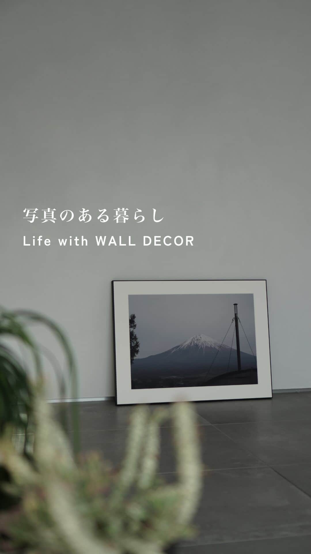 WALL DECOR (ウォールデコ）のインスタグラム：「【写真のある暮らし】  兵庫県に住むデザイナー・@neutral_house_さんのご自宅。 ものが少なく余白が印象的な空間は「内で外を感じる」がテーマだそう。  「自然素材が好きなので植物だけではなく、 石や木などを取り入れ、触感や質感にこだわっています。 これから次第に好みが変わることも視野に、 全体は何にでも合うグレーの空間にしました」  そんな@neutral_house_さんに 好きな写真をパネルにできる「WALL DECOR」を 制作いただきました。  いつでもどこでも動かせるようにと、 壁に立てかけて、床置きで飾られています。  ーーーーーーーーーーーーーーーーー  「長男と私の二人で彼の小学校卒業に合わせ、 卒業旅行として富士山を見に行った時の写真です。  普段データで眺めている写真が 額装されて届いた時の嬉しさがありました。  自分で撮った写真は、現像しても アルバムにしまっていましたが、 「思い出」をインテリアとして飾る というのはとても良いなと感じました。  ただ長男と私の二人だけの思い出なので、 家族みんなでの写真も必要ですね（笑）」  ーーーーーーーーーーーーーーーーー  写真をパネルにできる「WALL DECOR」 ギャラリータイプ A2サイズ相当 ディープマット印刷  comment 「印画紙はディープマットを選んだのですが、ギャラリータイプの縁のマットな質感と馴染んでいてかなり気に入っています。リビングなど明るい空間においても反射が無く、インテリアとして見た時もかなり良いポイントでした。」  #ウォールデコ #お部屋に飾りたい1枚 #植物のある暮らし #カメラのある生活 #注文住宅 #写真好きな人とつながりたい #カメラ好きと繋がりたい #カメラ好きな人と繋がりたい #インテリア好き #インテリアデザイン　 #新築注文住宅  #部屋づくり#植物のある生活 #インテリア小物 #家づくりアイデア #シンプルインテリア #インテリア好きな人と繋がりたい #新築戸建 #グリーンのある生活 #グリーンのある暮らし #インテリアを楽しむ #インテリア好きと繋がりたい #カメラ好きな人とつながりたい #家づくりノート 　#写真のある生活 #インテリアスタイリング #中庭のある暮らし #フォトパネル #ビンテージ家具」