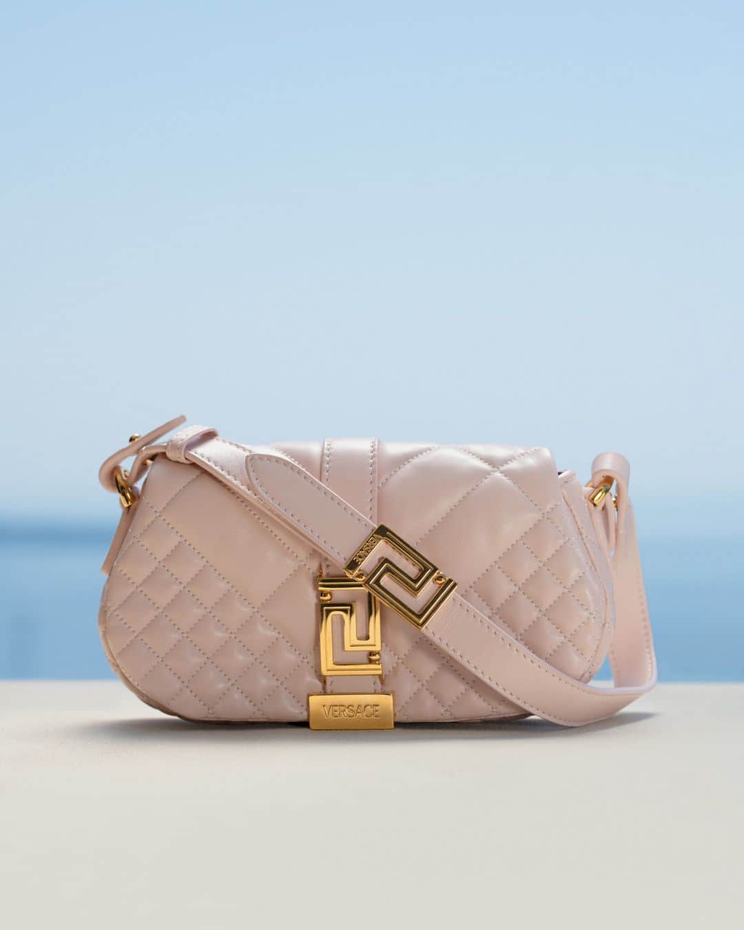 ジャンニヴェルサーチのインスタグラム：「The Greca Goddess mini bag for #VersaceLaVacanza  Versace is pleased to donate a percentage of sales from the Greca Goddess mini bag in powder blush pink to the Elton John AIDS Foundation during the month of June to celebrate Pride Month, with the style in pink chosen for the color’s representation of sexuality and sexual freedom in the LGBTQIA+ Pride flag.  @ejaf #VersaceGrecaGoddess」