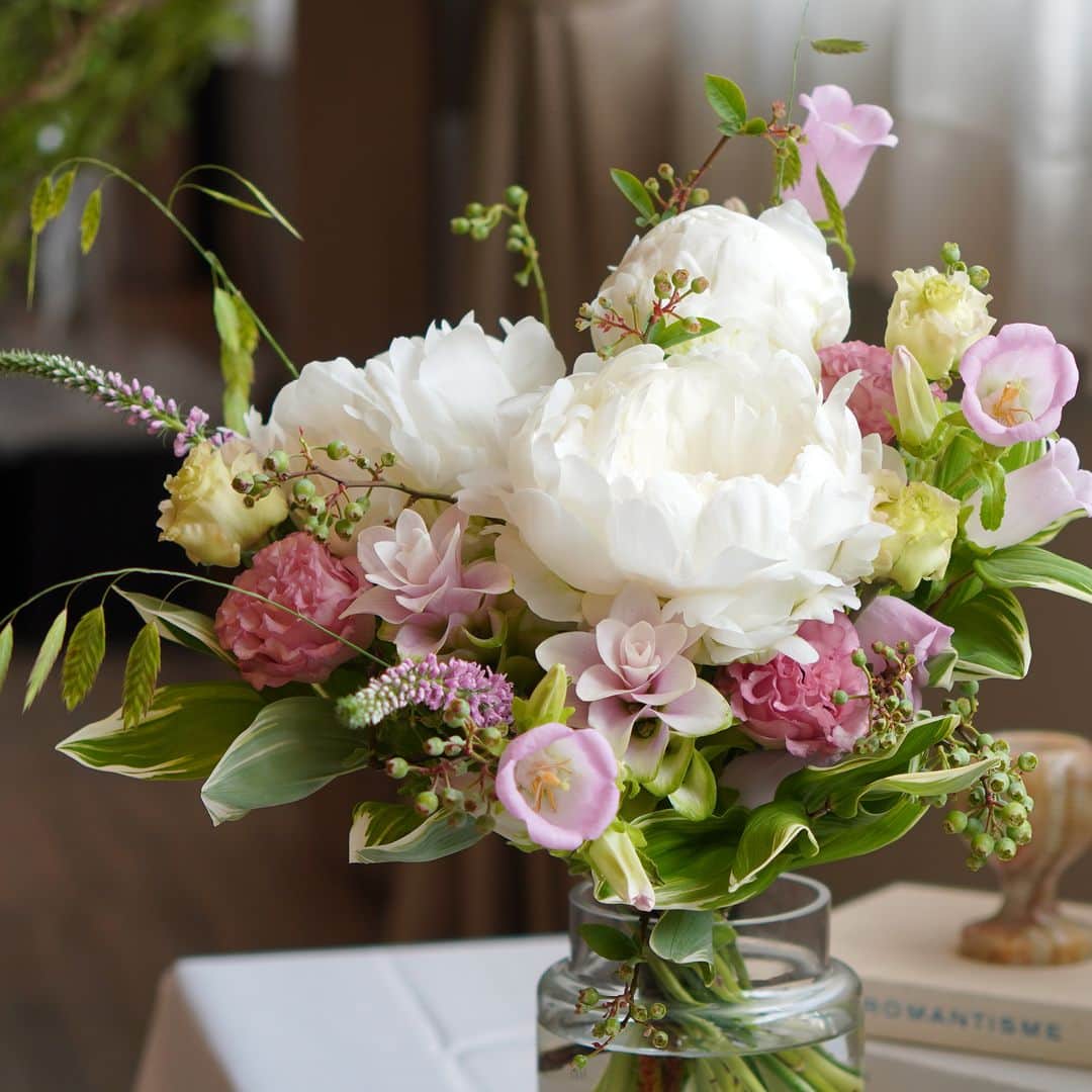 AOYAMA_HANAMOさんのインスタグラム写真 - (AOYAMA_HANAMOInstagram)「優美な白い芍薬と淡いピンクの花々の、上品な花合わせ。 ・ 白い芍薬をメインに、カンパニュラやトルコキキョウ、クルクマなど。白と淡いピンクの旬の花々でお作りした「#季節の花の定期便」です。ブルーベリーの実、ランダムな動きのグリーンスケールなどを添えて、穏やかで上品なデザインに仕上げました。 ・ 白い芍薬といっても、純白のものもあれば、ベージュやアイボリーに近い色味の品種もあります。同じ色でも微妙に異なる花色を比べてみるのも面白いですね。 ・ 青山花茂の「#季節の花の定期便」は、その時期に最適な花を使ってフラワーデザイナーがひとつひとつお作りしています。 これからの季節、涼しさを感じる花々を飾ってみてはいかがでしょう。ぜひ花のある暮らしをお楽しみください。 - - - #aoyamahanamo #青山花茂 #お花のある生活 #花が好きな人と繋がりたい #花を飾ろう #花のある暮らし #花のあるくらし #花のある日常 #癒しの花 #季節の花 #旬の花 #花のサブスク #フラワーサブスクリプション #お花の定期便 #季節の花の定期便 #季節の花の定期便プレミアムプラン #芍薬 #シャクヤク #ピオニー #トルコキキョウ #カンパニュラ #ベロニカ #クルクマ #グリーンスケール #花瓶活け #花束 #ブーケ #ナチュラルブーケ #初夏の花」6月1日 18時17分 - aoyama_hanamo