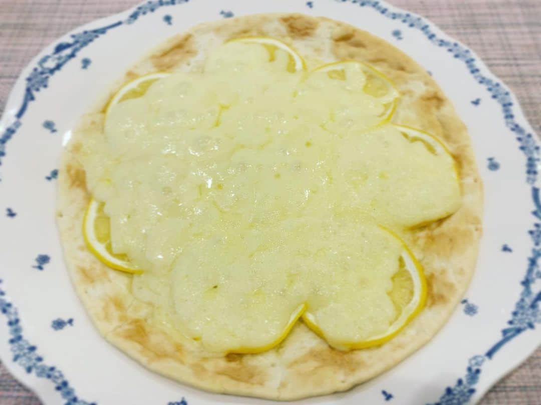 のインスタグラム：「「レモンピザ」！！ きょうのDayDay.冒頭でご紹介した私の（ほぼ唯一の…）得意料理。  ☆フォロワーさんのお知らせにより、僕が記憶していたのは熊本市のイタリアンレストラン「ロッソ」さんのお料理と判明しました。ホンモノはもっとめちゃくちゃおいしいと思います。  ↓以下は、私の勝手なレシピですよ〜  作り方は、生地の上にスライスレモンを並べ、チーズをかけて焼くだけ。 簡単です！みなさんぜひ作ってみてね。本当においしいですよ。 コツは、レモンをなるべくうす〜くスライスすること。レモンを多く並べすぎないこと。チーズはドバッとかけることです。 お好みで、ゴルゴンゾーラやハチミツを乗せてもいいですよ（2枚目です）。 今回は既成の生地を使いましたが、以前は粉をこねて作ったことも。 晴れた日に生地をラップで包んでクルマのボンネットの上に置いておくと、いい感じに膨れました。  もっとこうしたら美味しくなる！など、皆さんのアイディアを教えてもらえたら嬉しいです。」