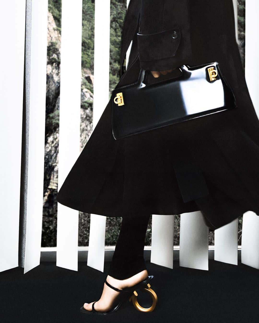 のインスタグラム：「SETTING THE PACE. BLACK SUEDE TRENCH, WANDA BAG AND ELINA SANDALS.  #FERRAGAMOSS23 #FERRAGAMOWANDABAG #FERRAGAMOELINA」
