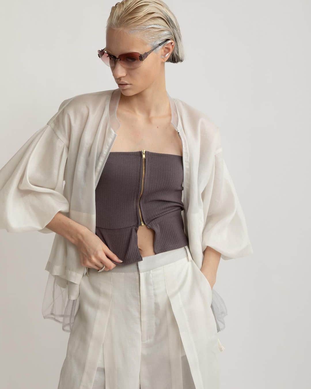 AULA AILAのインスタグラム：「【2023 HIGH SUMMER COLLECTION】  HALF SLEEVE LAYERED BLOUSON COLOR WHITE SIZE 0 ¥25,300  薄手のレザーのような光沢感と本来のスパンボイルの透け感が相まって、新鮮な印象に。  タックでボリュームたっぷりな5分袖のブルゾンです。  春から晩夏にかけて、長く着られる、軽い羽織りです。  見頃は内側にチュールがレイヤードされているため、裾からチュールが覗き、シアー感が涼し気なデザイン。  オーバーシルエットで、後ろはフレアーで裾が長いので、ヒップまわりをカバーしてくれて安心。   ✔️AULA AILA OFFICIAL WEB STOREにて HIGH SUMMER COLLECTIONアイテム展開中！」