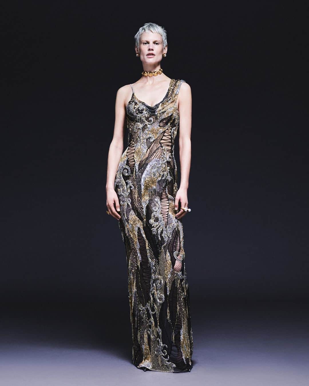 ジャンニヴェルサーチのインスタグラム：「Atelier Versace Spring-Summer 2023  Look 16  Column dress "crystalized knit" in transparent tulle base with all-over mini crystal construction in net, mini fringe, crystal thread, crystalized knit, and an interplay of Barocco motifs. Spontaneous shoulder is finished in asymmetric draping.  Look 8  Lace-up front mini dress in bright pink silk satin with embroidered lace intarsia. Bust cups finished in overstitch. Cinched and draped waist above hand pleated skirt with overall look inspired by lingerie and exposed undergarments.  Look 14  Silk tulle dress in degradé black and pink, with micro-draped structure flowing to the natural lines of the body and secured with sinuous chain. Black latex gloves.  Now at Versace.com via the link in bio.  #AtelierVersace」