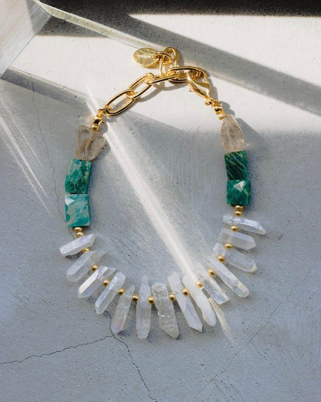 M U R R A Lのインスタグラム：「2023 Spring / Summer Collection  NUDE  "GARDEN" necklace  天然の鉱石を大胆に使用したアクセサリー。 ブランドらしい独特のカラーバランスや1点ずつ異なるカットの鉱石を使用したアクセサリーはまるで"等身大"を称えるかのように純粋だ。  ニュートラルカラーにグリーンがアクセントになったブレスレットはモノトーンコーディネートのアクセントに。  これから迎える新しい季節。 すぐ側にNUDEを感じられるようにと鉱石に願いを込めて。  #MURRAL #23SS #NUDE」