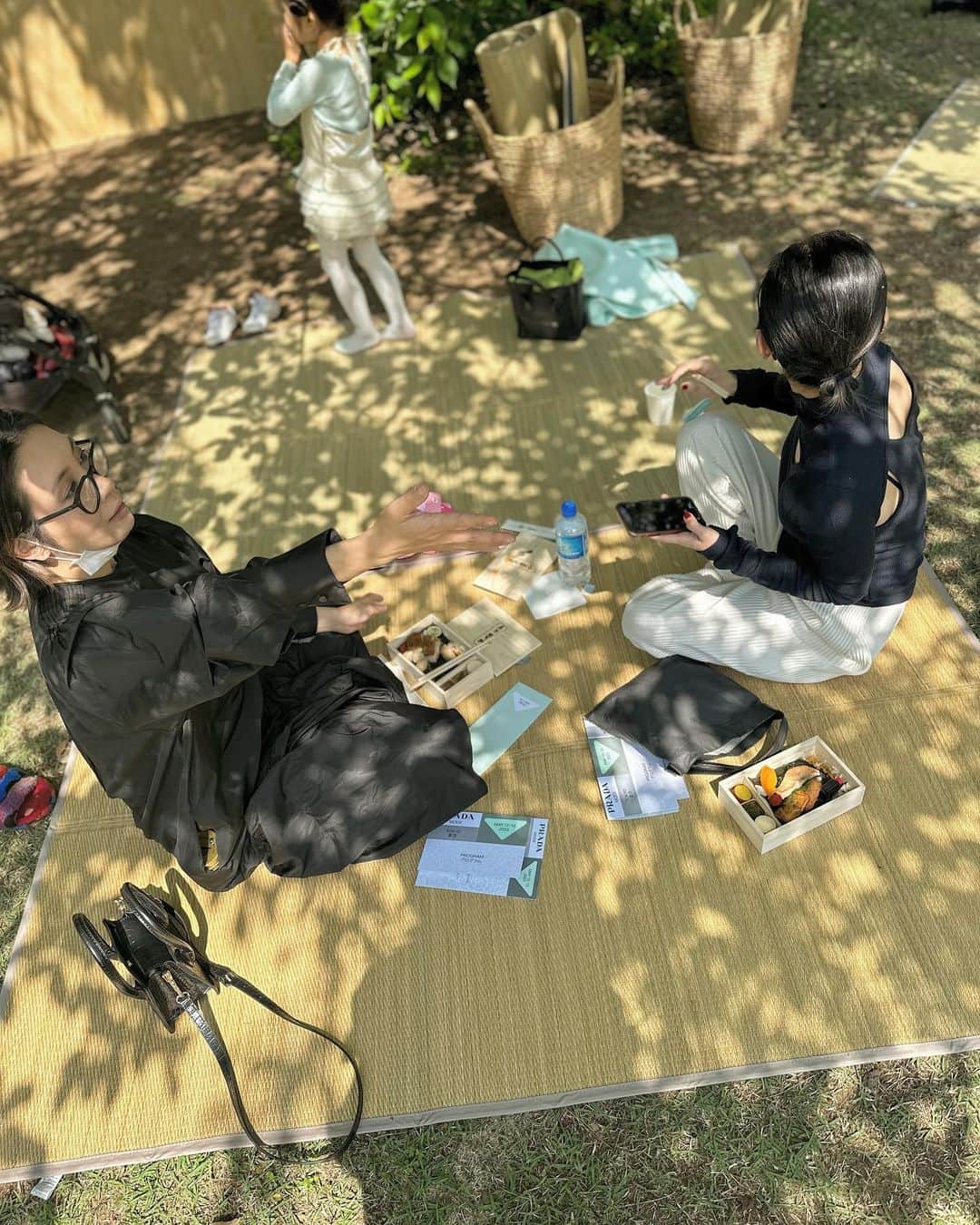 ミラクルひかるのインスタグラム：「アレレ　PRADAの前に葬式帰りのおばさんが立ってますねw  よく晴れた昼下がり。美しい庭園に作られたバカンスな空間。　ござを敷いてPRADA弁当とシャンパン。　　サルー！ フミコちゃん有り難う🌵 #pradamood  #東京都庭園美術館   ＰＳ.ゴー＆ユーヤ先生に荒削りの新ネタ『MEGUMI』さんのものまねをモラハラしてきました」