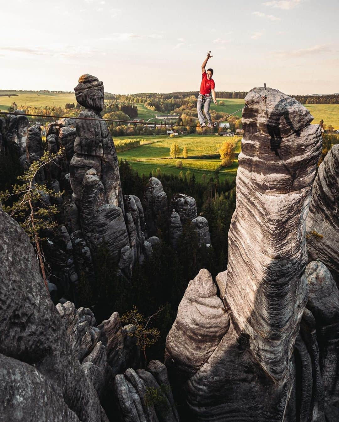 ティム・ケンプルのインスタグラム：「It’s been 15 years to the day that I landed in the Czech Republic with the @reelrock crew to capture photos of one of my very first @thenorthface expeditions. It’s crazy how much time has passed, but equally amazing how much hasn’t changed. We’re all still here doing the same thing and that’s pretty dang cool. ⁣ ⁣ This trip to the Czech was all climbing in #Adrspach at #TapliceRocks a legendary sandstone climbing area known for its epic beauty BUT also the local ethics that forbid traditional protection and chalk!⁣ ⁣ Feeling particularly fit, the team comprised of modern days legends @mattsegal @cedarwright @renan_ozturk @heidiwirtz and a young hot shot by the name of @alexhonnold set to work the first day to try and dispatch all of the area’s test pieces. It didn’t take long however for all of us to realize how hard these climbs were and even more important… how difficult they were to protect. SCARY doesn’t even begin to describe it! The team retreated to the pub after that first day with tails between our legs. It didn’t take too many pints to realize that we needed to check our egos at the door and have FUN if we were going to survive the trip with legs intact. ⁣ ⁣ We quickly made friends with locals at the bar and the next thing you know a couple weeks of some of the most epic climbing, cliff jumping, slack lines, and paramotors ensued. This was actually the first time I know of a ‘para motor’ being used to film or photograph in action sports a genius idea by the @mortimer_peter @nickynoodlenose and crew @senderfilms. Though maybe someone knows of early examples?⁣ ⁣ Overall everything you need in an epic ‘expedition’ and something that I still feel so fortunate to call my ‘job’ 15 years on.」