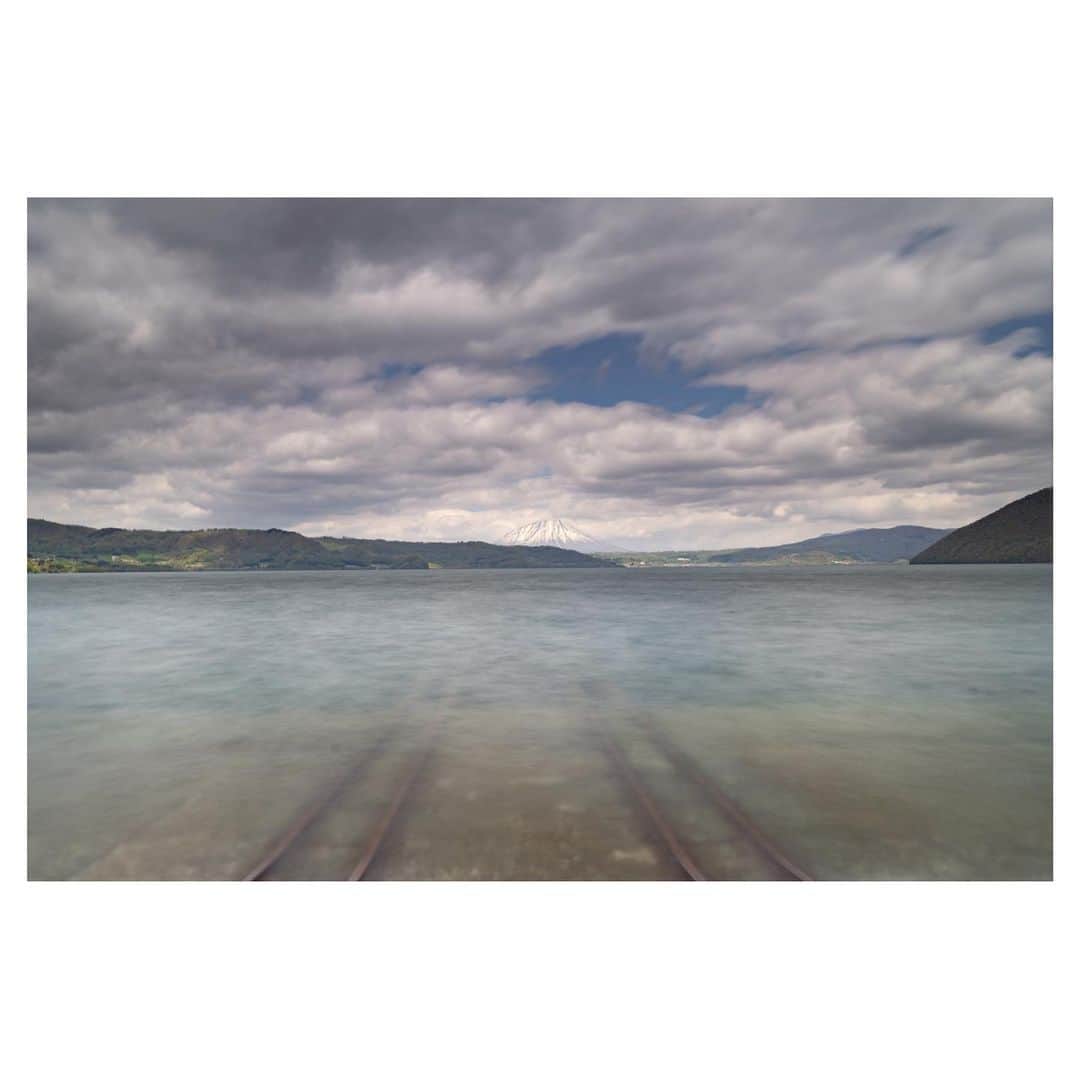 Hikaruのインスタグラム：「The mysterious railroad tracks leading to the sea and.  海の中に続く不思議な線路と。  巡り、廻り訪れて見つけた場所。 遠くに見える羊蹄山と。  #東京カメラ部 #nisifiltersjapan  #1x #raytrek #raytrek_photo #raytrek_uniquetome  #natgeo #naturegeography #photogrena_nature #photo_shorttrip #japan #hokkaido #写真好きな人と繋がりたい #北海道 #Japan_ilc #japantravelers #raytrek_photographer #SonyAlphaPro #photo_shorttrip #photo_travelers #lovers_nippon #1x_japan #bestjapanpics #SonywordClub #genic #alpha_newgeneration」