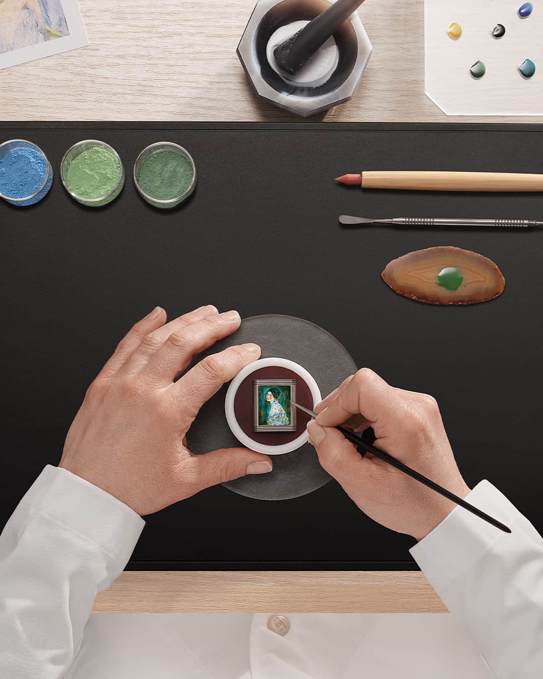 ジャガールクルトのインスタグラム：「Illuminating our Manufacture’s artistic creations. #InTheMaking _ In The Making, Enamelling. Discover watchmaking like never before. _ As complex as it is meticulous, the Grand Feu Miniature enamelling requires exceptional expertise. Using tiny brushes, our artisans reproduce portraits and landscapes over approximately 2cm2. The enamel is then fixed in ovens, which are heated to over 800 C°; this is known as the Grand Feu technique.  _ #JaegerLeCoultre #InTheMaking #Craftsmanship #SavoirFaire」