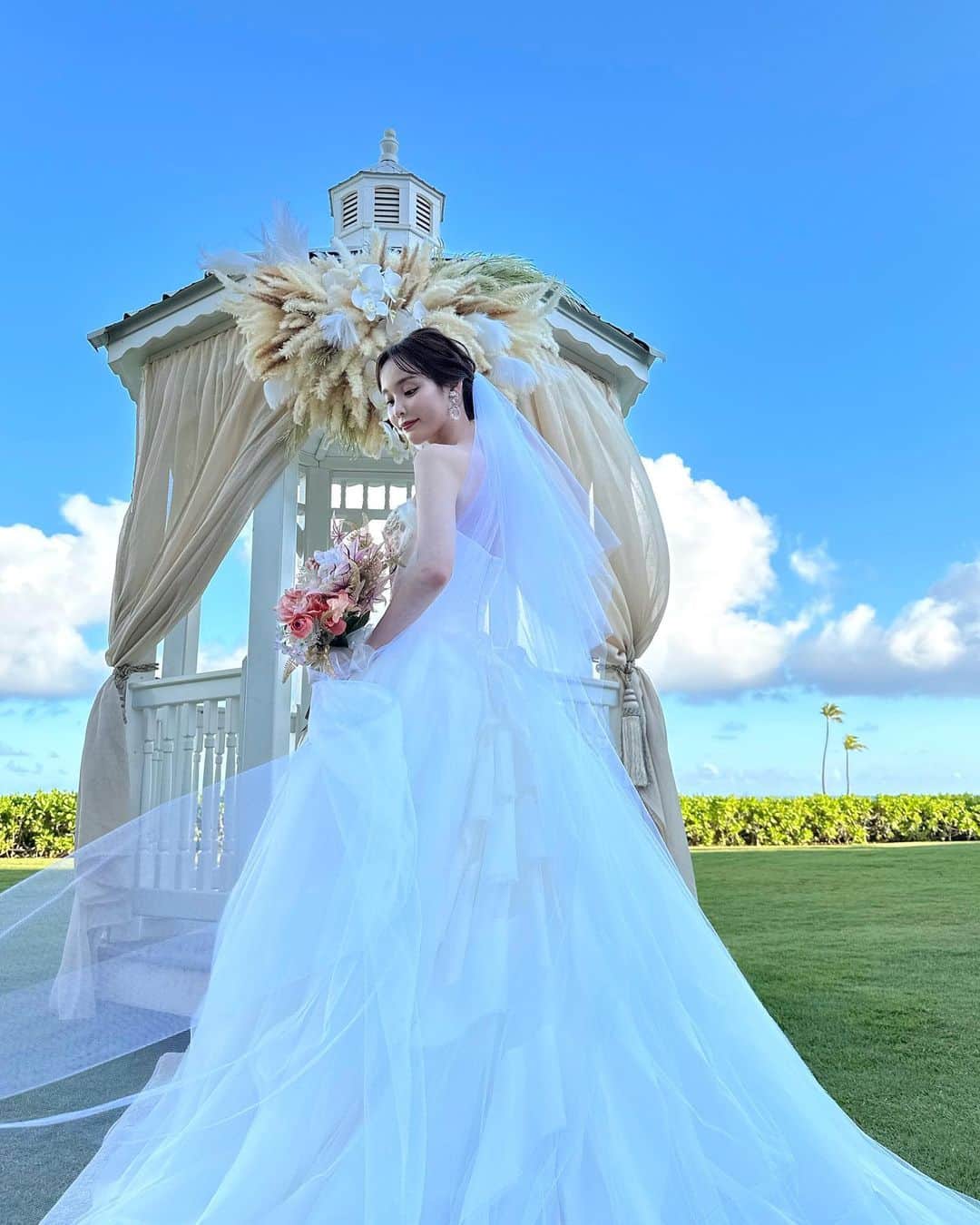 磯田 ひかる(Hikaru Isoda) のインスタグラム：「先日、無事に結婚式を挙げることができました💐💍  念願のガーデンウエディングで、心配していたお天気にも恵まれ。 家族と友人と一緒に過ごせた素敵な1日になりました🥰  ハワイだし、カジュアルにやりたいと思ってたから結婚式の前日に両親にお手紙渡したの✉️ その時も泣いてたし、挙式前も泣いてたからまっすぐ顔見れなかった🥹  お友達は色々制限のあるなかでこんな遠いところまで来てくれて、本当に嬉しかった🥲💕  ハワイに行く度、思い出の場所に何度も行けるといいなぁと思ってカハラホテルにしました🤍 ドレスは胸元の刺繍がカハラホテルのイメージにピッタリで選びました！  厳選した10枚どれにするか悩みすぎて載せるの遅くなりました...🙏」