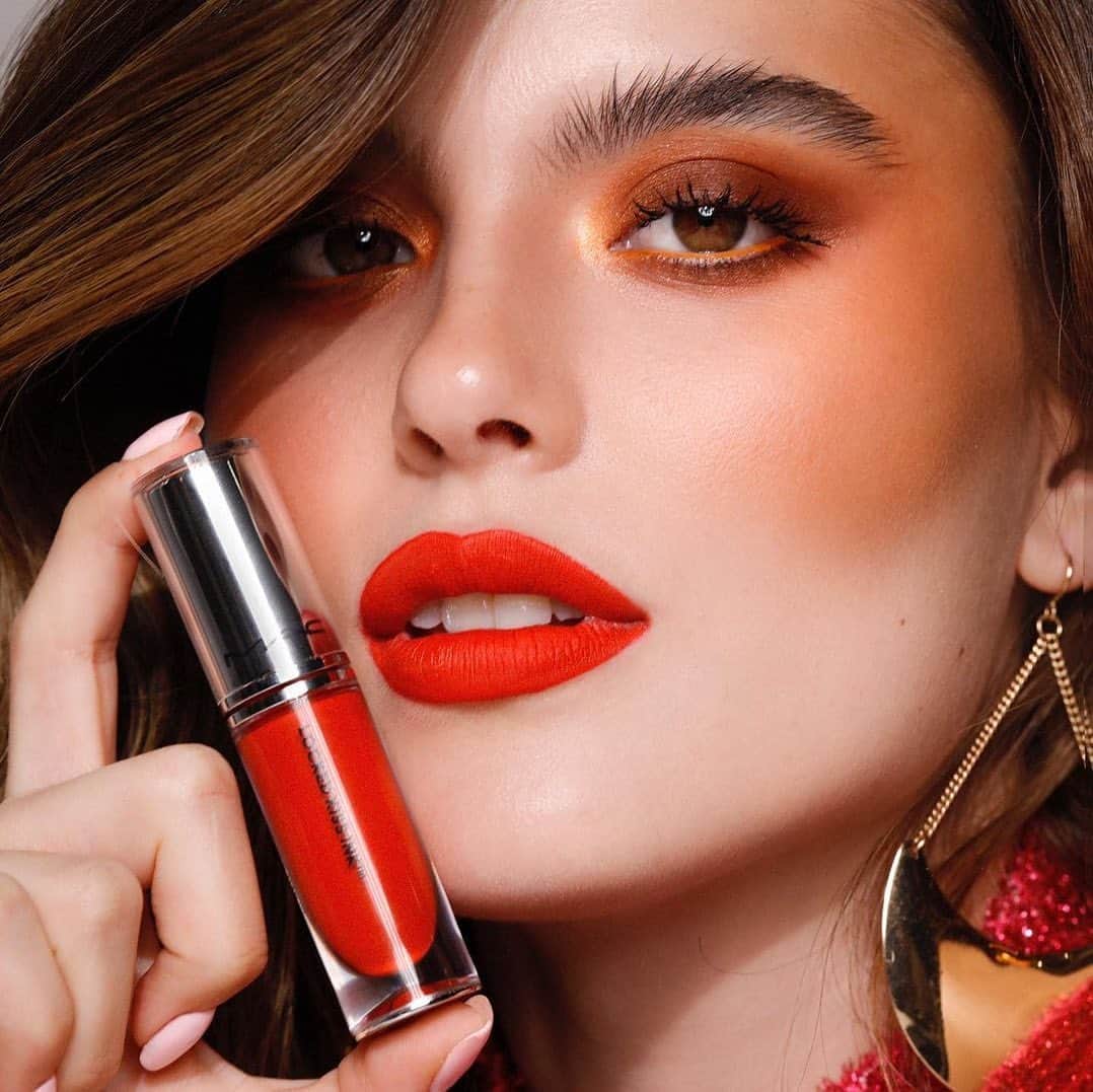 のインスタグラム：「A cor da estação esá em alta com a #MACTrend #ORANGESPRITZ 🧡🍂 A paleta do laranja e tons terrosos é a cara do Outono e perfeita pra você invesrtir essa semana 🥰 Quem te ajuda a garantir o visual é o batom Locked Kiss Ink em Gutsy, um tom vermelho tomate apaixonante e completamente envolvente 😍  Ela usou:  🧡 Batom Locked Kiss Ink em Gutsy 🧡 Sombra para olhos Refil Pan / Paleta Pro em Red Brick 🧡 Sombra para olhos Refil Pan / Paleta Pro em Rule  🧡 Sombra para olhos Refil Pan / Paleta Pro em Orb  🧡 Sombra para olhos Refil Pan / Paleta Pro em Paradisco  Toque na tela a garanta a cor da semana.   #ParaTodoMundoVer: na imagem aparece uma modelo branca usando o batom Locked Kiss Ink na cor Gutsy, um tom de vermelho aralanjado, ela segura ao lado dos lábios o batom e usa nos olhos uma sombra esfumada em tons terrosos e laranjados.   #MACLockedKissInk」