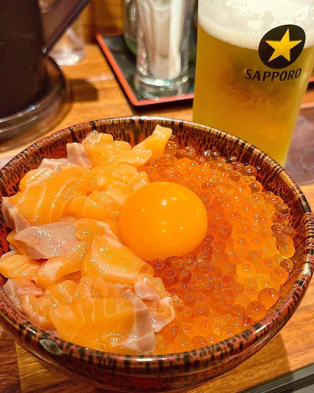 永岡怜子のインスタグラム：「久々にふらりとひとり呑み🍻  波の渋谷東店さん🐟  渋谷東店は渋谷の氷川神社の近く。 私はという人間は参拝後の清らかな心で さらに幸せを浴びに来た欲深い人間です。 神様ごめんなさい。  .  お昼は行列ができているところを良く見かけますが 夜は並ばず入れました👌🏻 メインは美しく映える海鮮丼ですが せんべろメニューもあるのが良いですね。  悩んで悩んで「本気の親子丼」を。。。 卵黄も乗って最後にお茶漬けもできて1700円、 ビールと一緒でも2300円はお得すぎる。。。  店員様が提供時に説明してくださいますが こちらの丼はお醤油をかけていただきます。 サーモンといくら、 この間違いのない組み合わせは間違いなく美味しい。 全日本人が本能で知っていると言っても 過言ではないですね。  生魚を食べる事もそうなのですが、 白米に生卵をかけて食べる事ができるのは 日本くらいだと聞きますからね。 日本人に生まれた事を神様に感謝しつつ卵黄を潰し 卵かけごはん状態で感じるいくらの主張も美味です。  何よりありがたいのが 少食の悪魔の私でも食べ切れるサイズ感の丼。 ごはんを残す事により 一抹の罪悪感を抱え店を後にする事が多いので 小さめの丼は少食にとっては嬉しいポイントに。  ちなみにごはんは大盛りもありますし お茶漬けにする際は食べ終わってからでも ごはんを追加して作ってくださいます。 サーモンも一切れ乗せてくれるようです。 もちろん食べている途中でもOK。  私はいい塩梅でネタとごはんを残し お茶漬けにしていただきました。 お茶漬けのお出汁の甘味と海苔の風味に ネギがガツンと来るのがとても良い。。。  ちょうど良い腹加減、ビールも1杯に抑え 幸せかつ健全に帰宅いたしました✨ 酒量はいつもこのくらいに抑えたいのですが 何故かすいすい進んでしまうのですよね。 減酒祈願、酒乱除けの御守りが欲しい。。。  .  #酒乱のグルメ #たのしい隠居生活  #渋谷グルメ #渋谷ランチ #海鮮丼 #海鮮丼🐟 #サーモン #サーモン丼 #いくら丼 #ビール女子 #ビール部 #ひとりごはん #ひとり飲み #ソロ活  #美食 #美食推薦 #美食日記 #japanesefood #japanesefoodlover #sashimi  #donburi #beerlovers #beerstagram #🐟」