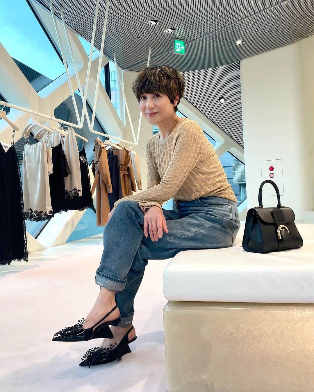 黒田知永子のインスタグラム：「. 危険⚠️近寄るな！ 散財注意報🚨 でも行っちゃう笑 青山PRADA🩵 私達の世代はキルティングのバッグの頃から…ずっと、“おしゃれなイタリア”を感じるブランド🇮🇹 あ〜ミラノのガッレリアにあるお店に行きたいなぁ〜なんてお気に入りのGOLD KNIT を着て思うのです。懲りない私。  Knit・denim・shoes… @prada  bag… @delvaux   #prada #黒田知永子 #chiekokuroda」