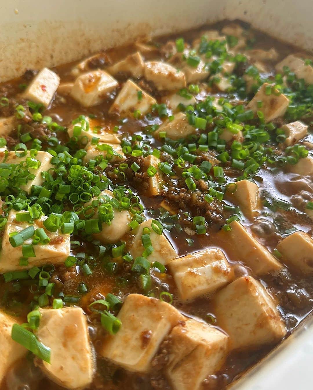 岡本安代のインスタグラム：「【思いやりの麻婆豆腐】 今夜は麻婆豆腐です。 大阪公演出発前に作り置きをした麻婆ソースで作りました。  留守番チームに負担ないようにと作っていった作り置きでしたが、大千穐楽を終えて帰宅するとまだまだ残っていました。  『あら？！全て使い切る計算で作って行ったのに、なんかあった？！』  『いやー、俺もママがせっかく作り置きしてくれたから、食べようって言ったんだけどさ、自分達で作れる時は作ろうって言って、セーマンがいろいろ作ってくれたんだよ。公演終わりで作り置きが残っていれば、鹿児島に帰ってきてからのママの負担が減るだろうからってさ。』  冷凍していた麻婆ソース。 解凍と共に、夫の言葉が溶け出して、母不在のキッチンでの様子に想いを馳せる本家台所番長。（←私。）  みんなで食べる麻婆豆腐。  辛いはずなのに、とても優しい味がする。。。  嗚呼、ありがたいこと限りなし。  #走り続ける岡本家 #５人の子育てママウンサー  #岡本安代 #麻婆豆腐 #作り置き #おうちごはん」