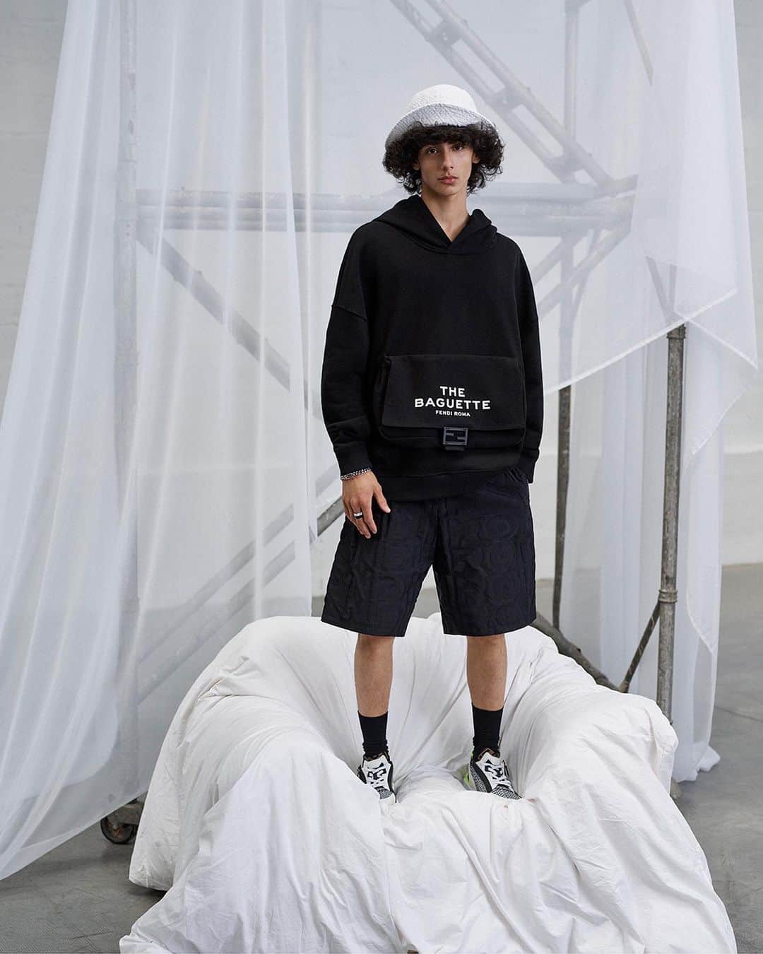 Fendiのインスタグラム：「Celebrating the icon. The silhouette of the #FendiBaguette and Marc Jacobs' lettering feature on hoodies, tees, and hats in #MarcJacobsXFendi.  Artistic Director of Accessories and Menswear: @silviaventurinifendi  Artistic Director of Jewelry: @delfinadelettrez Artistic Director: @themarcjacobs  Photography: @brunostaub   Styling: @ganio Makeup: @makiryoke Hair: @jimmypaulhair Set Design: @mattjacksonmattjackson  Casting: @piergiorgio  Models: Mehdi Abouzaid, Jonas Manuel」