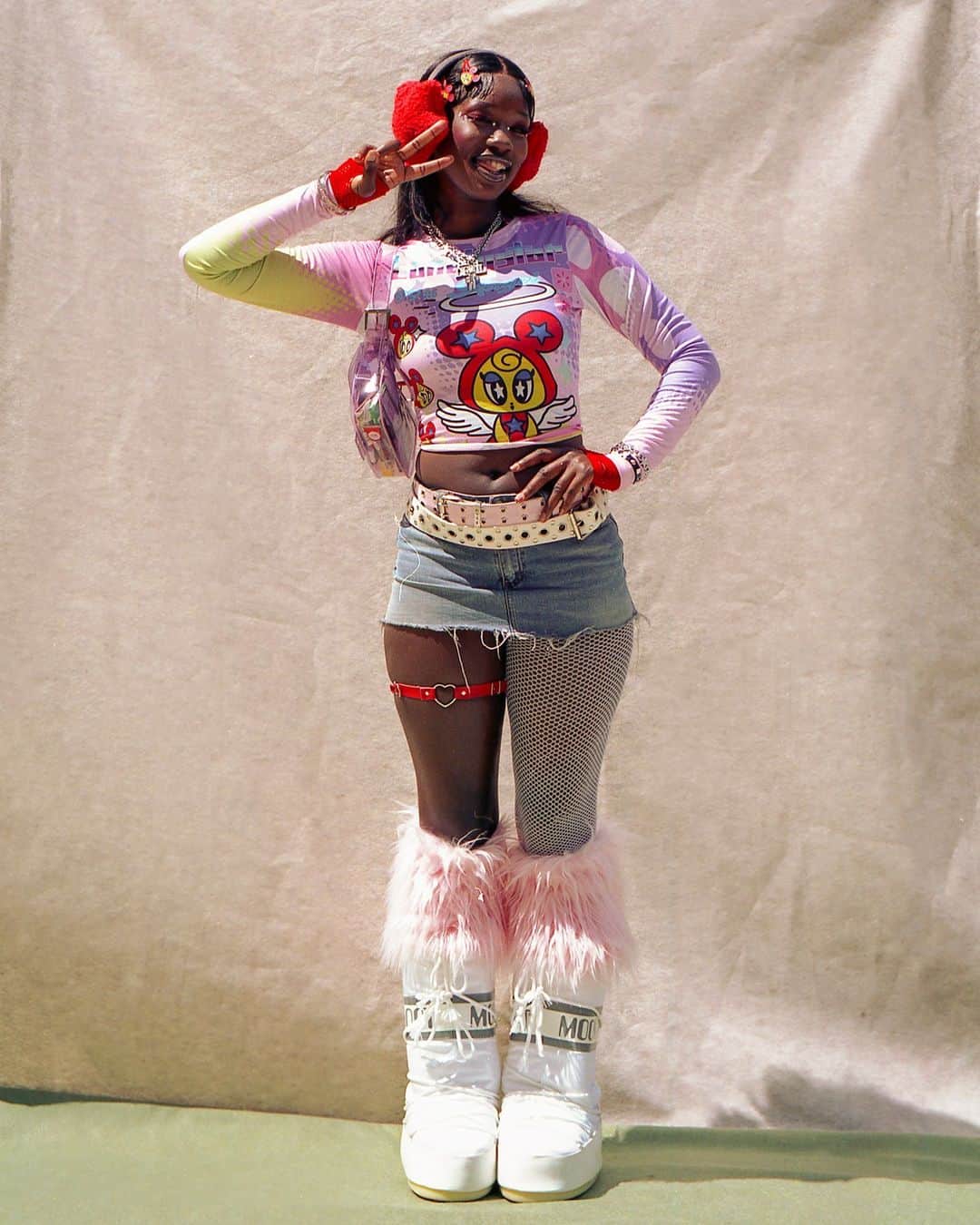 New York Times Fashionのインスタグラム：「Aliyah Bah cultivated her aesthetic — a hodgepodge of Y2K, alternative and harajuku style — and watched it take off online. Now, the 20-year-old former college student is the woman behind Aliyahcore.  @aliyahsinterlude has created a singular look. In addition to earmuffs and a miniskirt (or really short shorts), Aliyahcore ensembles usually include crop tops, fishnet stockings over one leg and both arms, knee-high platform moon boots trimmed with fur, a garter belt, makeup that matches the shade of the outfit, and a flurry of hair accessories.  Bah’s style has been resonating with an audience of more than three million followers across her social media accounts. Lizzo recently posted a video to her Instagram account where she was dressed head to toe in Aliyahcore: red moon boots topped with white fur, a white garter belt, a denim shorts-and-crop-top set, and pink furry headphones.  Bah said she finds deeper purpose in her style’s popularity. “Being Black is what people see, obviously, whenever I wear anything,” she said, referring to how her style subverts expectations of how Black women are supposed to dress. “When I see a lot of dark skinned girls dressed up in Aliyahcore, it makes me really happy because I never saw it growing up.”  Read more from @s_evangelina about Aliyahcore at the link in our bio. Photo by @wulf.bradley」