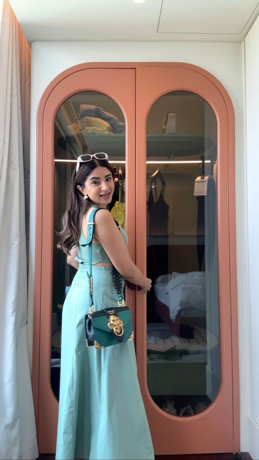 Aashna Shroffのインスタグラム：「hello from my Bangkok wardrobe and probably one of the cutest wardrobes I’ve seen ever! a little GRWM from our first day here with @pradabeauty!🤍   dress @zara bag, sunglasses and fragrance @prada earrings @toryburch」