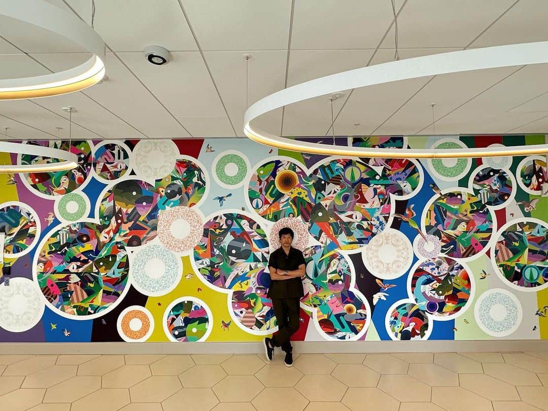 松山智一のインスタグラム：「Public art for a good cause. mural for @upstatemedical university, Nappi Wellness Institute in Syracuse NY. A project with @rxart  Thanks  to @dianebrownrxart , @chrissalgardo @atwaterskincare  -----------------------  医療施設にパブリックアートを届ける財団RX Art @rxart との協業で完成した壁画。NYのUpstate Medical University 大学病院にて。行政、教育機関、芸術財団が連携を取り医療施設内に同時代性や文化を用い環境整備を行う姿勢は美しい。 施設関係者たちの見解を交え作品制作を行うことは容易ではなかったが、忘れ難い記憶だ。」