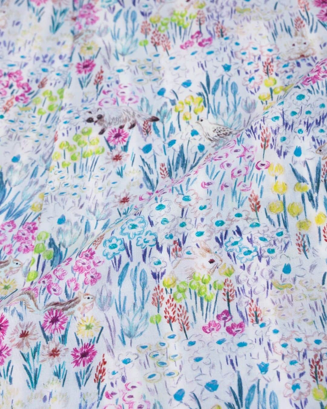 marbleSUD(マーブルシュッド) のインスタグラム：「【23MS collection】 ［明るい方へ：あかるいほうへ］ 金子みすゞさんの詩、「明るい方へ」からインスピレーションを得て生まれたテキスタイルです。  薮草も、虫も、人間も、みんな光を求めて明るい方へ向かっていく。  そんな景色をイメージして色鉛筆で描いた花畑の風景にやわらかな光と影を重ね、その対比を表現して描かれています💐」