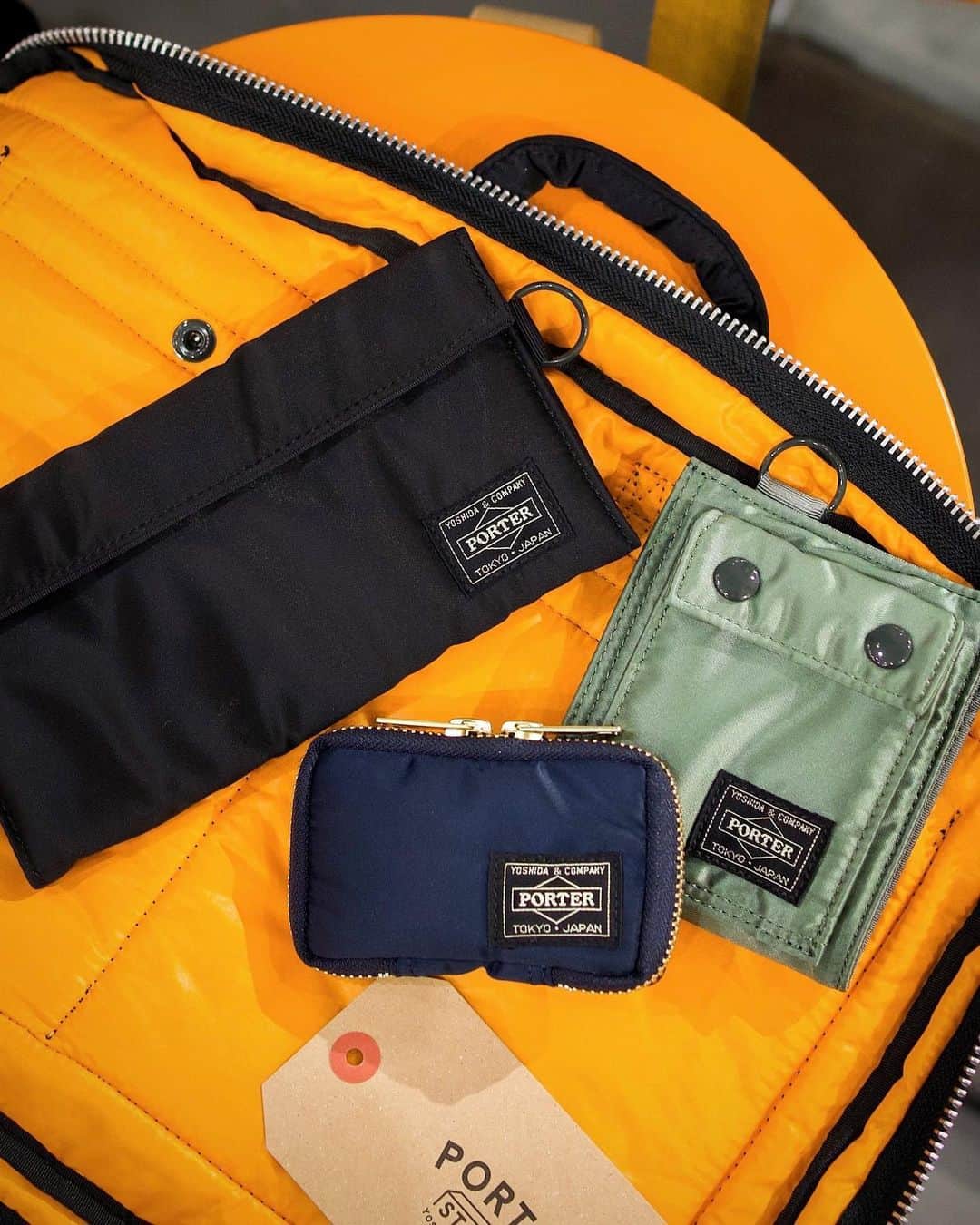 のインスタグラム：「⁡ PORTER TANKER ⁡ KEY CASE No.622-77138 ¥8,580(tax included) W95/H55/D20mm ⁡ WALLET No.622-78168 ¥10,450(tax included) W100/H120/D0mm ⁡ LONG WALLET No.622-78166 ¥12,650(tax included) W200/H110/D0mm ⁡ 1983年に発表された、PORTERの代名詞である「TANKER」シリーズです。 ⁡ アメリカ空軍のフライトジャケット「MA-1」をモチーフに開発したオリジナルの3層構造生地を採用しています。ナイロンツイル（表面）+ポリエステル綿（中間層）+ナイロンタフタ（裏面）の3レイヤー生地はとても軽く、ボンディング素材の柔らかな感触と裏面の鮮やかなレスキューオレンジが魅力です。裁断から縫製・パーツに至るすべての工程で、吉田カバンの職人の徹底したこだわりが詰まったシリーズです。 ⁡ 是非、店頭でお手に取ってご覧ください。 ⁡ ※吉田カバンオフィシャルオンラインストアからでもご購入いただけます。 ⁡ ※商品の詳細はプロフィールのURLからご覧いただけます。 ⁡ ※各店の営業時間は下記をご確認ください。 PORTER STAND SHINJUKU 11:00（土日祝10:30）〜21:00 PORTER STAND SHINAGAWA 8:00〜22:00（日祝21:00） PORTER STAND KYOTO 10:00〜18:00 ⁡ #yoshidakaban #porter #luggagelabel #potr #yoshida #porteryoshida #porterstand #shinjuku #shinagawa #kyoto #madeinjapan #japan #tanker #portertanker #keycase #wallet #longwallet #gbp #吉田カバン #ポーター #ポータースタンド #新宿 #品川 #京都 #ルミネエスト #駅ナカ #産寧坂 #タンカー #キーケース #ウォレット」