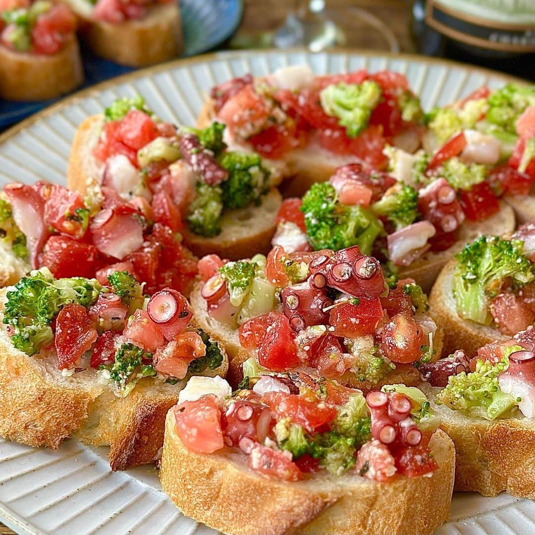 しにゃさんのインスタグラム写真 - (しにゃInstagram)「今日はタコとトマトとブロッコリーを使ったごちそうブルスケッタをご紹介します🤗✨ タコのうま味とトマトの酸味、にんにくとバジルをきかせたオイルがめちゃウマです😋💕 粉チーズを加えることでコクが出て、めっちゃ美味しくなりますよ🙌🏻 キンキンのワインやスパークリングにピッタリで、これからの季節のおうち飲みや女子会に大活躍間違いなしです😆✨ それでは作り方をご紹介します✨       タコとトマトとブロッコリーの ごちそうブルスケッタ  【材料】３～４人分 ◎タコ(ボイル)・・・１５０g ◎トマト・・・１個 ◎ブロッコリー・・・１／２株 ◎バゲット・・・１本 （調味料） ◎オリーブオイル・・・大さじ３ ◎粉チーズ・・・大さじ１ ◎にんにく（チューブ）・・・小さじ１ ◎塩・・・小さじ１／２〜１ ◎バジル(乾燥)・・・適量 ◎ブラックペッパー・・・適量      【作り方】 １．ブロッコリーを小房に切り分け茹で、水気を切って細かく刻みます。 ※花蕾の部分が上、軸が下になるように茹でるのがポイントです。   ２．タコとトマトを１cm角に切ります  ３．ボウルにタコ、トマト、ブロッコリー、(調味料)を加えて混ぜ合わせ、冷蔵庫で冷やします。 ※塩は分量に幅をもたせてますので、味見しながら調整してください。   ４．バゲットをお好みの厚みに切り、お好みで軽く焼きます。   ５．③がしっかり冷えたらバゲットに乗せて器に盛りつけ完成です。     味はもちろん、見た目も鮮やかでホームパーティーに最高です😊✨ これからの暑い季節にもぴったりなので、ぜひお試しくださいね😆🙌🏻        より詳しいレシピはお手数ですがブログを見てください🤗✨ プロフィール欄のURL(@shinya6727 )、もしくはストーリーズのスワイプから飛べます😌✨  【お知らせ】 私の２冊目のレシピ本、「しにゃのやみつき！つまみ飯」重版されております🙌🏻 いつも応援してくださる皆さまのおかげです😂🙏 なるべくシンプルな食材や調味料、どこにでもある調理器具を使って作れるやみつきレシピをまとめた１冊になっております📚 お料理が好きな方も苦手な方も楽しんでいただける内容になっています😊  いつも通りの鶏むね肉やもやし、厚揚げといった、リーズナブルでヘルシーな食材を使った大満足レシピを多数掲載してます🙌🏻 とにかく幅広い方のお役に立てるレシピ本となっていますので、多くの方に手に取っていただけたら嬉しく思います😌🙏 お買い求めはAmazon、楽天などのネット通販か、全国の書店で📚 どうぞよろしくお願いします😊 ・ ・ ・ #レシピ #recipe #簡単レシピ #料理 #おうちごはん #おうち飲み #タコ #チーズ #おつまみ #cheese #トマト #tomatoes #bread #ブルスケッタ #ワイン」5月21日 20時27分 - shinya6727