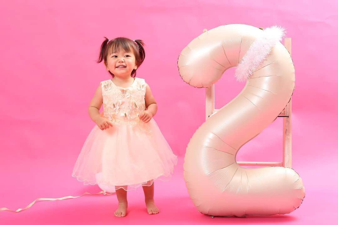 中嶋真緒のインスタグラム：「⁡ 今日は日翠の2歳のお誕生日🎂 ⁡ 羊水が増えると言われれば 言われた通りお灸を受けて 産みやすくなると言われれば マッサージを受けて（いいカモすぎw） 早く産みたいと毎日3時間歩き、 計画分娩の予定日に病院に行ったら こりゃまだまだ産めないからまたあと1週間 歩いてね〜といわれて絶望感で泣き、 歩くのもやめて好き放題食べてた3日後に 生まれてきた日翠ちゃん♡ ⁡ たくさん歌って、話せる言葉も増えて 毎日凄い勢いで成長していくので 親としては言葉遣いに気をつけて生活する日々。 ⁡ ⁡ ジェンダーについて色々話題になる 世の中ですがとりあえず私は フリフリのお洋服にラメラメの鞄や靴👑 細くて短い髪の毛を無理矢理結んで ぷりぷりキラキラ女子を育て中です❤️‍🔥 ⁡ ⁡ 日翠ちゃんが生まれてから私が本当に幸せ♡  #ちなみに友達の子ももれなく我が子の様に可愛い #母性強め 笑 #2歳誕生日 #お誕生日 #記念写真 #娘 #女の子ママ」