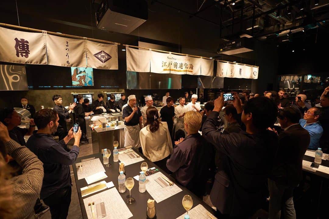 本田直之さんのインスタグラム写真 - (本田直之Instagram)「東京都が主催するDelicious Museumの虎ノ門サテライト会場のイベントをプロデュースしました。  世界中からたった36人だけを招待したこの日ここだけの 江戸4大料理の進化を食べながら学ぶシークレットイベント  江戸前進化論 Evolution of Edomae Ten Hands Dinner @ Social Kitchen Toranomon  村上千砂さん経由で東京都から依頼を受けたときに、世界に誇れる東京らしい食のイベントって何だろう？と考え、悩みに悩んで、やっぱり一番シンプルでストレートなもので行こうと思った。  それは東京の食文化の歴史を紐解くこと。  外食文化が隆盛を極めた江戸時代の四大料理といえば、屋台での鮨、天婦羅、鰻、蕎麦。  伝統的料理とはいうが、江戸時代に食べていたものと、現代で食べられているものでは格段に進化をとげている。 この伝統の進化を食べながら感じてもらいたいなと。  令和の今の人気店がその進化した江戸前の料理を提供する。  江戸と現代を繋ぐネオ屋台的な、ライブ感溢れるSocial Kitchen虎ノ門に暖簾を掲げ、オープンキッチンの目の前で料理されたものを、コースのようにハシゴしながら立食で楽しんでもらう。  映像では江戸時代の4大料理の映像を流し、食べながら当時の東京の食文化を感じてもらえるようにしました。  そしてこのテーマを表現するのが世界に誇れる5人のシェフ達 鮨まつうら 松浦修 天ぷら元吉 元吉和仁 おそばの甲賀 甲賀宏 鰻八重洲はし本 橋本正平 そして全体を統括する意味でアジアベストレストラン50の1位に輝いた、傳の長谷川在佑  ペアリングには Ruinart Blanc de Blancs 仙禽オーガニックナチュール 新政陽乃鳥 IWA5 山ねこ銅釜蒸留 山崎12年 アサヒスーパードライ生ジョッキ缶  DJはもちろんFPM田中さんにこのコンセプトに合う音楽をミックスしてもらいました。オリンピックのためにアレンジした、上を向いて歩こうのボレロリミックスはオープニングに相応しく感動的だった。  参加頂いた皆様、ありがとうございました！ そして5人のシェフ、こっしー、スポンサーの皆さん、博報堂、キリンジ、Social Kitchen虎ノ門のスタッフの皆様、誰もやったことがない、クレイジーな企画に付き合っていただき、ありがとうございました！  Produced a secret, invitation-only event where top chefs of the four major Edo cuisines (sushi, tempura, soba, and eel) served Edomae.  We held an event themed on the evolution of Tokyo's food culture from Edo period (1603-1868 CE) to the present day, bringing together famous restaurants serving the four major Edo-mae cuisines, where you can enjoy a standing as if you were eating at a food stall back then, hopping each restaurant's dishes as if they were courses.   Sushi Matsuura, Osamu Matsuura Tempura Motoyoshi,  Kazuhito Motoyoshi Osoba no Koga, Hiroshi Koga Unagi Hashimoto of Eel Yaesu, Shohei Hashimoto and Zaiyu Hasegawa of Den, winner of the first prize of Asia's 50 Best Restaurants.  #江戸前進化論 #デリシャスミュージアム  #江戸前」5月23日 9時59分 - naohawaii