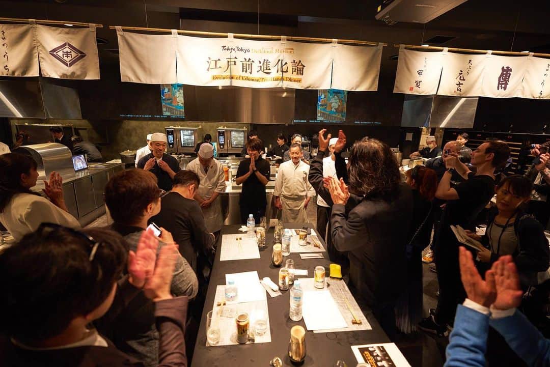 本田直之さんのインスタグラム写真 - (本田直之Instagram)「東京都が主催するDelicious Museumの虎ノ門サテライト会場のイベントをプロデュースしました。  世界中からたった36人だけを招待したこの日ここだけの 江戸4大料理の進化を食べながら学ぶシークレットイベント  江戸前進化論 Evolution of Edomae Ten Hands Dinner @ Social Kitchen Toranomon  村上千砂さん経由で東京都から依頼を受けたときに、世界に誇れる東京らしい食のイベントって何だろう？と考え、悩みに悩んで、やっぱり一番シンプルでストレートなもので行こうと思った。  それは東京の食文化の歴史を紐解くこと。  外食文化が隆盛を極めた江戸時代の四大料理といえば、屋台での鮨、天婦羅、鰻、蕎麦。  伝統的料理とはいうが、江戸時代に食べていたものと、現代で食べられているものでは格段に進化をとげている。 この伝統の進化を食べながら感じてもらいたいなと。  令和の今の人気店がその進化した江戸前の料理を提供する。  江戸と現代を繋ぐネオ屋台的な、ライブ感溢れるSocial Kitchen虎ノ門に暖簾を掲げ、オープンキッチンの目の前で料理されたものを、コースのようにハシゴしながら立食で楽しんでもらう。  映像では江戸時代の4大料理の映像を流し、食べながら当時の東京の食文化を感じてもらえるようにしました。  そしてこのテーマを表現するのが世界に誇れる5人のシェフ達 鮨まつうら 松浦修 天ぷら元吉 元吉和仁 おそばの甲賀 甲賀宏 鰻八重洲はし本 橋本正平 そして全体を統括する意味でアジアベストレストラン50の1位に輝いた、傳の長谷川在佑  ペアリングには Ruinart Blanc de Blancs 仙禽オーガニックナチュール 新政陽乃鳥 IWA5 山ねこ銅釜蒸留 山崎12年 アサヒスーパードライ生ジョッキ缶  DJはもちろんFPM田中さんにこのコンセプトに合う音楽をミックスしてもらいました。オリンピックのためにアレンジした、上を向いて歩こうのボレロリミックスはオープニングに相応しく感動的だった。  参加頂いた皆様、ありがとうございました！ そして5人のシェフ、こっしー、スポンサーの皆さん、博報堂、キリンジ、Social Kitchen虎ノ門のスタッフの皆様、誰もやったことがない、クレイジーな企画に付き合っていただき、ありがとうございました！  Produced a secret, invitation-only event where top chefs of the four major Edo cuisines (sushi, tempura, soba, and eel) served Edomae.  We held an event themed on the evolution of Tokyo's food culture from Edo period (1603-1868 CE) to the present day, bringing together famous restaurants serving the four major Edo-mae cuisines, where you can enjoy a standing as if you were eating at a food stall back then, hopping each restaurant's dishes as if they were courses.   Sushi Matsuura, Osamu Matsuura Tempura Motoyoshi,  Kazuhito Motoyoshi Osoba no Koga, Hiroshi Koga Unagi Hashimoto of Eel Yaesu, Shohei Hashimoto and Zaiyu Hasegawa of Den, winner of the first prize of Asia's 50 Best Restaurants.  #江戸前進化論 #デリシャスミュージアム  #江戸前」5月23日 9時59分 - naohawaii