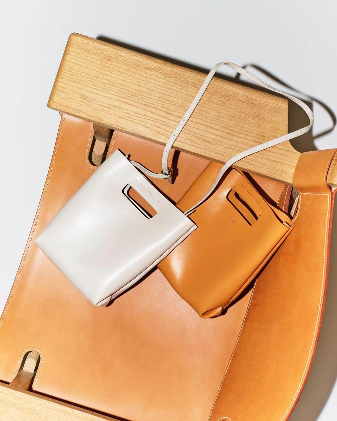LOVELESS/GUILD PRIME 公式アカウントのインスタグラム：「『 FEATURE 』 SUMMER MUST BUY vol.2 -WOMEN- 夏に向けたバイヤーレコメンドアイテム  【YAHKI】HAND BAG  実用性はもちろんミニマルデザインが魅力の「YAHKI(ヤーキ)」のバッグをご紹介。W FACEレザーのスクエア型クロスボディバッグはハンドバッグとしてもショルダーバッグとしても使用できる2WAY仕様。大きすぎず、小さすぎない絶妙なサイズ感はシーンを選ばず普段使いに丁度良い形です。ソフトレザーを使用しているため、柔らかい印象に。 ショルダーの長さも変えられるので、その時のコーデに合わせて、クロスにも肩掛けにも対応可能な万能BAG。使い勝手の良さと絶妙なバランスの装飾性はこの夏の大本命ではないでしょうか。  Bag ￥26,400 (641-16-155) @yahki_tokyo」