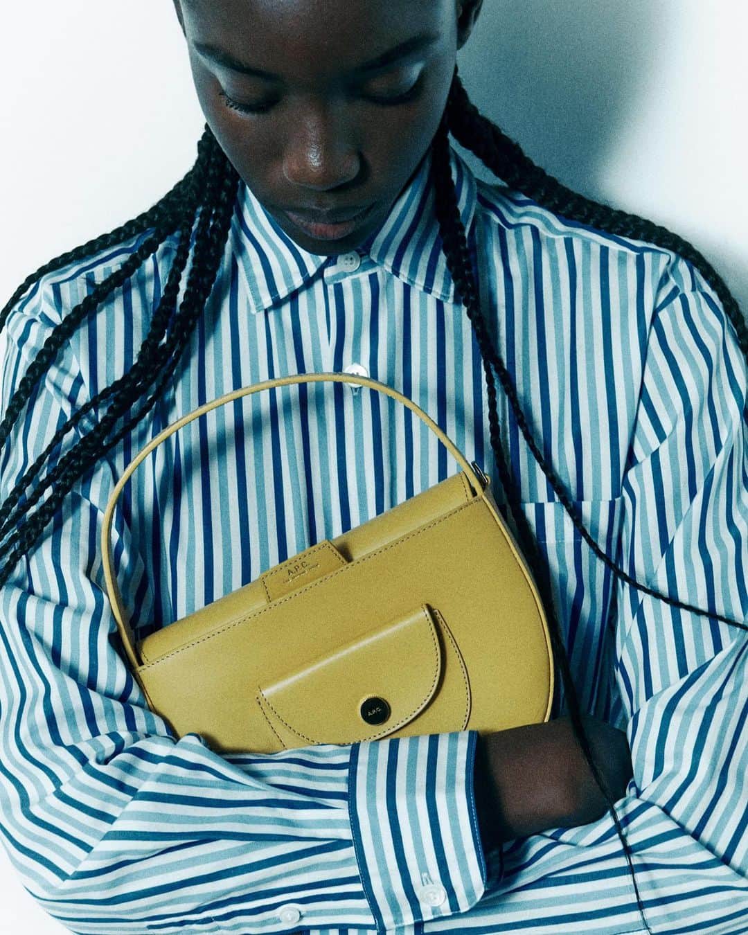 アーペーセーのインスタグラム：「A.P.C. Pocket - the bag of the season.   Taking the characteristic geometrical shape of the great classic that is the A.P.C. demi-lune, the Pocket has, as its name implies, a small external snap pocket. Itself a semicircle, it gives it a real touch of fantasy.   Available in hazelnut, black as well a as a seasonal bold yellow shade for those looking to make a color statement.  #APCParis」