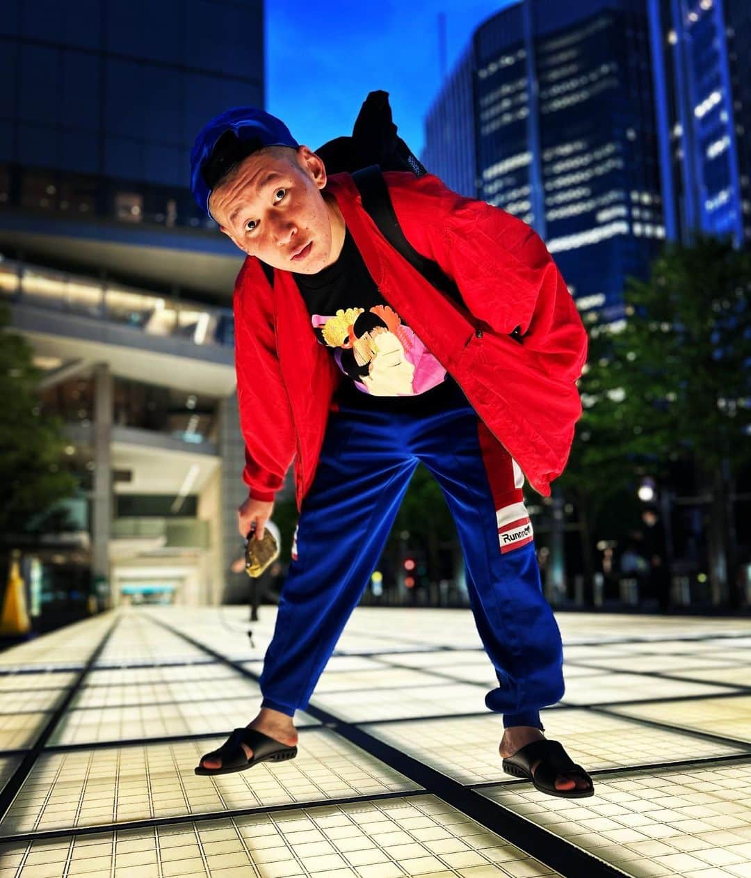 のインスタグラム：「今日の服装。 昼飯を坂井さんと食べて散歩して出張ルミネで有楽町。  この時期の気候は絶妙に難しい。 外国人観光客向けの店で購入した半袖の舞妓のTシャツに便利すぎる赤のジャケット。 RUN BIRDのパロディジャージRUNNING。 綺麗な青の帽子に黒の便所サンダルmont-bellのメッシュリュック。  有楽町出番終わりで輝く地面があったので悪戦苦闘しながら携帯置いて撮りました。 輝く地面ありがとう。 6/17.19:00〜新ネタワンマンお待ちしてます。  #今日着た服 #ファッション #古着 #有楽町 #舞妓 #悪戦苦闘 #覗き込みスタイル」