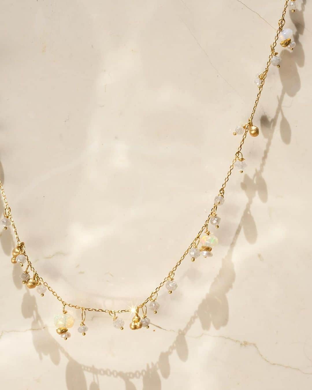 muskaのインスタグラム：「<üzüm> Opal & Diamond Necklace 繊細なチェーンに、惜しげもなくダイヤモンドやオパールを散りばめたネックレスは、光を受け上品に輝きを放ちます。  葡萄の果実を模した小さなゴールドパーツがチェーンの上を転がる、遊び心とエレガンスが共存するデザインです。  #muskajewelry #the6thnight #delicatenecklace #goldnecklace #diamondnecklace #ダイヤモンドネックレス #ロングネックレス #ネックレス #ゴールドネックレス」