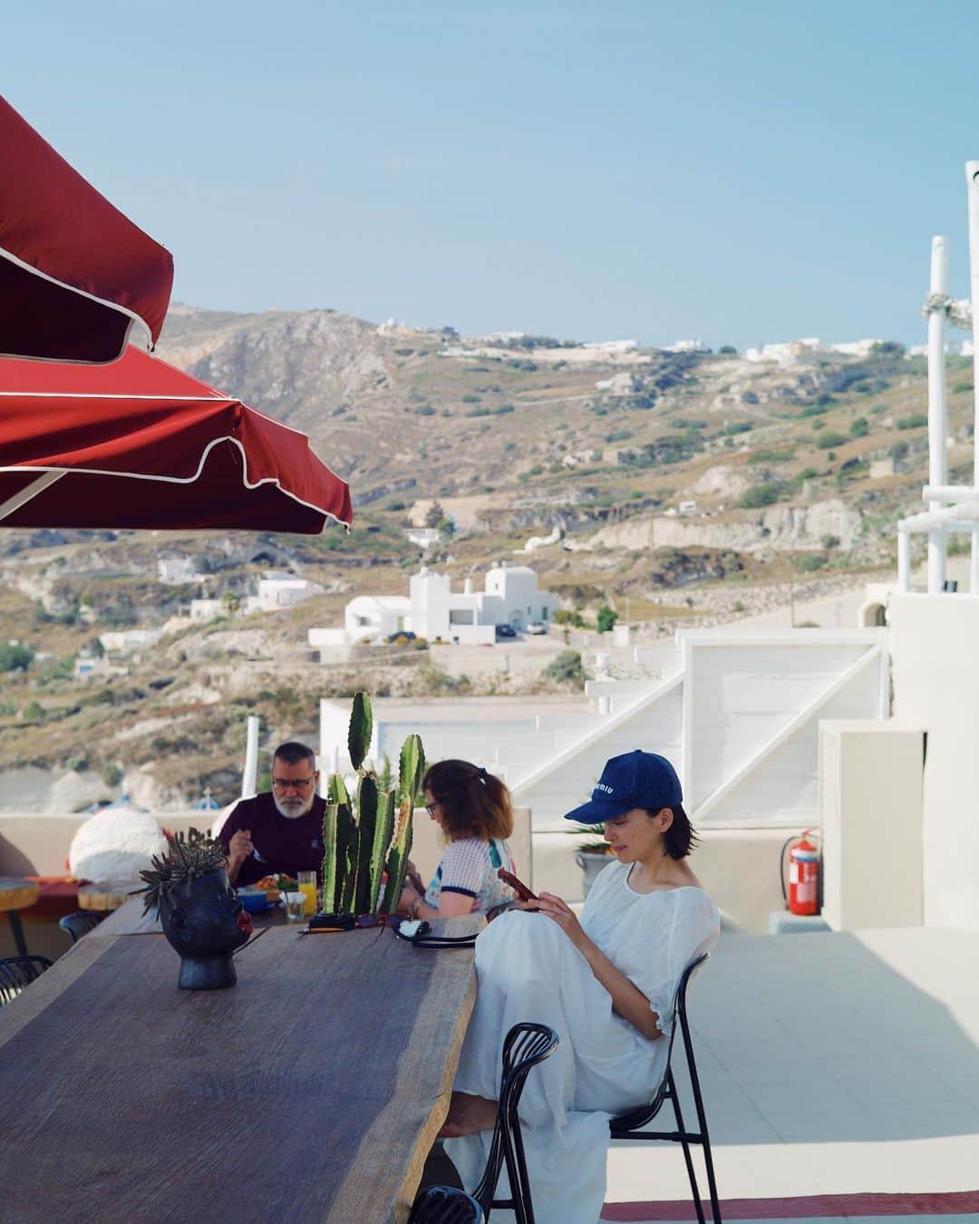 高山都さんのインスタグラム写真 - (高山都Instagram)「サントリーニ島は黒着てる人がほんとうに少ない。  とにかく白い建物と青い海のコントラストが素晴らしく、どこを切り取っても可愛い。 (建物の白は壁を石灰で塗ってるのだそう。だから白い。陽射しが強いから少しでも部屋の温度を低くするためになのだそう。あと、青の差し色も塗料で安くすぐ利用できるものだったからだそう。)  世界中の観光客が各々のカラフルなリゾートファッション楽しんでるのを観察するのも面白くて、いろんなマダムたちを見てる。 素敵な彼女たちにドレス可愛い！って言ったら、会話が始まって(英語は全然話せませんが)すれ違いぎわに挨拶したり、SNSのアカウント聞かれたり。 ファッションから生まれるコミュニケーションだなーと思ったのでした。 もし、これから行かれる方は、日本だと勇気の出ないカラフルなものや、大きく開いたデザインの洋服も、ここだと平気で着られると思います。  夫は夫で、よくカメラ好きの紳士から声をかけられてる。 素敵ねーと声を掛け合う文化っていいな。  @oblekt_jp のオーガニックコットンのワンピースはインナーのキャミワンピがカップ付きだから、下着気にしなくていいし、旅先で洗濯してもすぐ乾く。  #都の旅の記録  #サントリーニ島 #都ふく」5月26日 20時58分 - miyare38