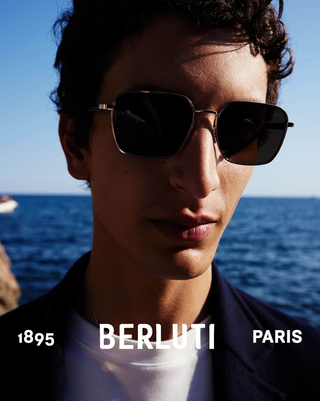 ベルルッティのインスタグラム：「- THE ACCESSORY: SUNGLASSES BY #BERLUTI -   Sunshine season calls for a go-to pair of eyewear. With their unique brand of cool, the Mercury sunglasses bet on signature Berluti details, from a delicate metal frame to nappa leather finishings on the temples and a subtle 1895 engraving on the edge of the lens.   Now available online and in-store.  Styling by @virginiebenarroch  Photography by @anthonyseklaoui」