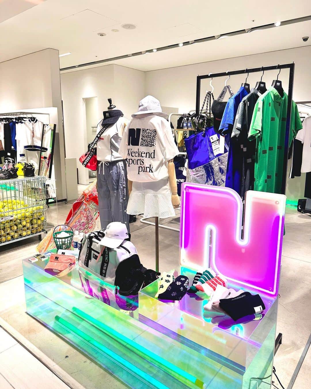 #ぶらエディターズ GINZA SIX オフィシャルのインスタグラム：「NBB WEEKEND POP-UP SHOP 4F @nbb_weekend   GINZA SIXの4Fで、ひときわプレイフルな空間で注目を集めているNBB WEEKEND®（エヌビービーウィークエンド）が、8/30(水)まで長期POP UP STORE を開催（📸1枚目）🎉 POP UPは昨年11月に続く2回目で、今回は売り場を拡大しての登場となっています👏🏻✨   「"Switch your mode" 新しい自分へ切り替わる。」をキャッチコピーに、自由でしなやかに生きる全ての女性へ、スポーツとファッションのハイブリッドをテーマにしたファッションを提案する、誕生2年目のエヌビービーウィークエンド🏌️‍♀️🎾🌤 “私服でも着られるスポーツウエア”ではなく、スポーツシーンやライフスタイルといったジャンルに捉われずに自由に纏える、現代に生きる女性へ向けた機能的でキャッチーなアイテムを展開しています✨   この春夏は、70～80年代のレトロスポーツがコレクションテーマ🏸🧢🎾本ストアでは、ブランドスタート当初からの大きなコンセプトである“スポーツファッション”と今季のテーマを最大限体感できるよう、“Weekend sports park”として架空のスポーツパークを再現（📹2枚）❣️店内にはテニスの審判台やバスケットボール、テニスボールなどが配され（📸3枚目）、店内に足を踏み入れると、そのプレイフルな空間に自然と心が躍ります👯‍♀️🎵💕   一点一点がキャッチーで「かわいい！」と手に取りたくなるウエアは、デザインだけでなくスポーツに適した機能性も搭載💡たとえばサステナブルな再生ポリエステル糸を使用したニットポロ＆スコート風スカート（📸4枚目左・税込24,200円、右・税込17,600円）は、身体をしっかり動かせる、窮屈のない軽快な着心地😊💯伸縮性性に富んだ型崩れしにくいダンボールニット生地を使用したシリーズ（📸5枚目左・税込25,300円、中・税込19,800円、右・税込26,400円）は、普段使いはもちろん、ゴルフやジムの行き帰りに着たいアイテムです🙌🏻   またモダンなウエアに合わせたい小物やグッズ類も豊富です👌🏻木々や芝生によく映える、スケルトンのオーロラカラーのゴルフバッグシリーズ（📸6枚目左・税込19,800円、中・税込14,300円、右・税込64,900円）は、ラウンドで注目されること間違いなし🏌️✨！個性を強調でき、スタイリングのポイントとなるソックスも多数ラインナップしているので（📸7枚目・税込1980円〜）、アクティブなシーンでも、エヌビービーウィークエンドなら自分らしさを取り入れられます💐   さらに注目したいのはコラボアイテム💥！EVERLAST @everlastとのダブルネームで展開しているベアトップ（📸8枚目左・税込16,500円）とスリーブレス（📸8枚目右・税込17,600円）は、ボクシングウエアのディテールを採用しつつも、他ブランドではなかなか見ないモードな印象に🕶✨またフットウエアブランドSHAKA @shaka_footwearとのコラボのサンダル（📸9枚目左・税込14,850円）は、ストラップが取り外しができる2WAY仕様。グリップ性の高いアウトソールを採用したスニーカーライクなはき心地なので、夏のアクティビティやフェスにもおすすめです🌟   エヌビービーウィークエンドは、今までECを中心に展開していて、ここまで大きな実店舗を構えるのは初めてとのこと👏🏻 “Weekend sports park”をプリントしたGINZA SIX 限定Tシャツ（📸10枚目・税込7,150円）も登場しているPOP UP STOREで、この夏のスポーツとアクティビティシーンをスタイリッシュに楽しむウエアを見つけてみませんか？😉🌤🌲   ―― 4F ☎ 080-4915-1336 ――   #nbbweekend #エヌビービーウィークエンド #fashion #ファッション #sports #スポーツ #夏ファッション #summerfashion #japanbrand #tennis #テニス #golf #ゴルフ #ゴルフ女子 #golfwear #golflife #ゴルフウェア #everlast #shaka #collaboration #コラボ #機能素材 #Tシャツ #wネーム #ginzasix_fashion #ginzasix_popup #ginza #銀座 #ginzasix #ギンザシックス   @ginzasix_official」