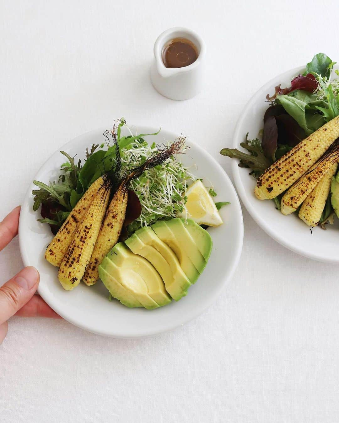 樋口正樹のインスタグラム：「Today's breakfast 🌽 🥑 🌿 . 今日の朝ご飯はサラダで アボカド、ベビーリーフ、 網焼きしたヤングコーン、 ブロッコリースプラウト。 あと写ってないけどパン。 . ドレッシングは玉ねぎの 北野エースで推しの１本🧅 @kitanoace . 先日始めたアボカド栽培、 新たにペルゥさんを追加。 . . #朝サラダ #アボカドサラダ #ヤングコーン #ブロッコリースーパースプラウト #ベビーリーフ #北海道タマネギドレッシング #サラダプレート #野菜を食べよう #野菜が美味しい #サラダ #ドレッシング #北野エース #北野エースで購入 #kitanoace #dressing #salad」