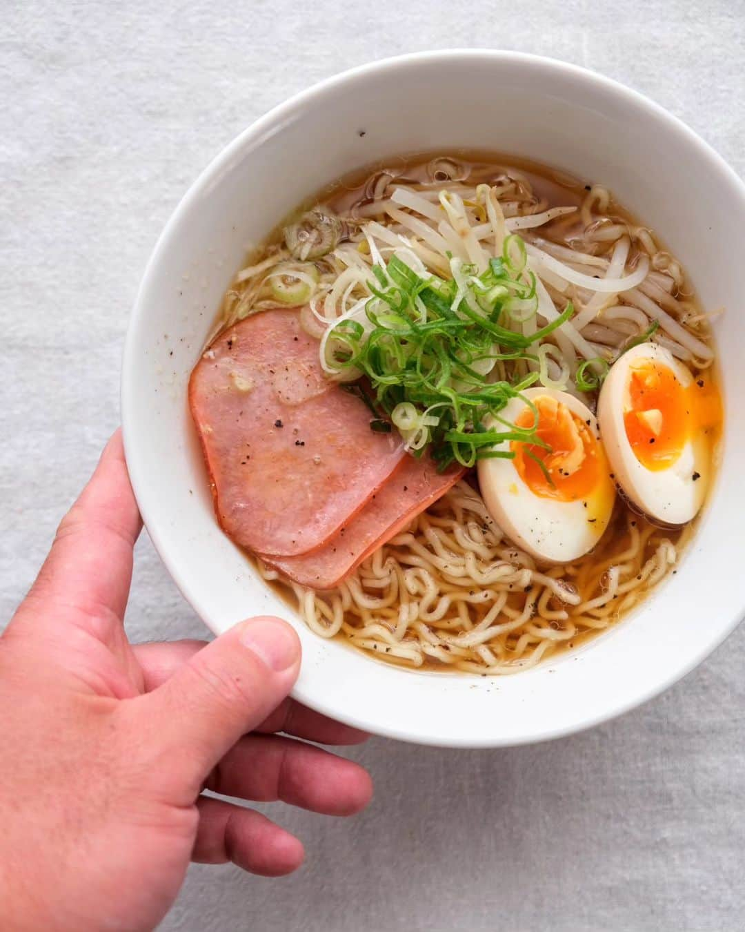 わたをのインスタグラム：「朝ラーメン🍜  母ちゃんがお土産に買って来てくれた邦栄堂製麺の醤油ラーメン。素朴な味わいのスープに、絶妙のひとつ上をいく縮れ麺がとてもよく合うてますな。目当ての餃子の皮は直前のお客さんに買い占められたってさ笑🤣ｵﾓﾛｰ  もやしにネギに味玉に、チャーシューなんて無いから普通のハムを焼いてのっけた。  #おうちごはん #朝ごはん #朝ラーメン #ラーメン #邦栄堂製麺 #Yummy #Delicious #Japan #japanesefood #breakfast」