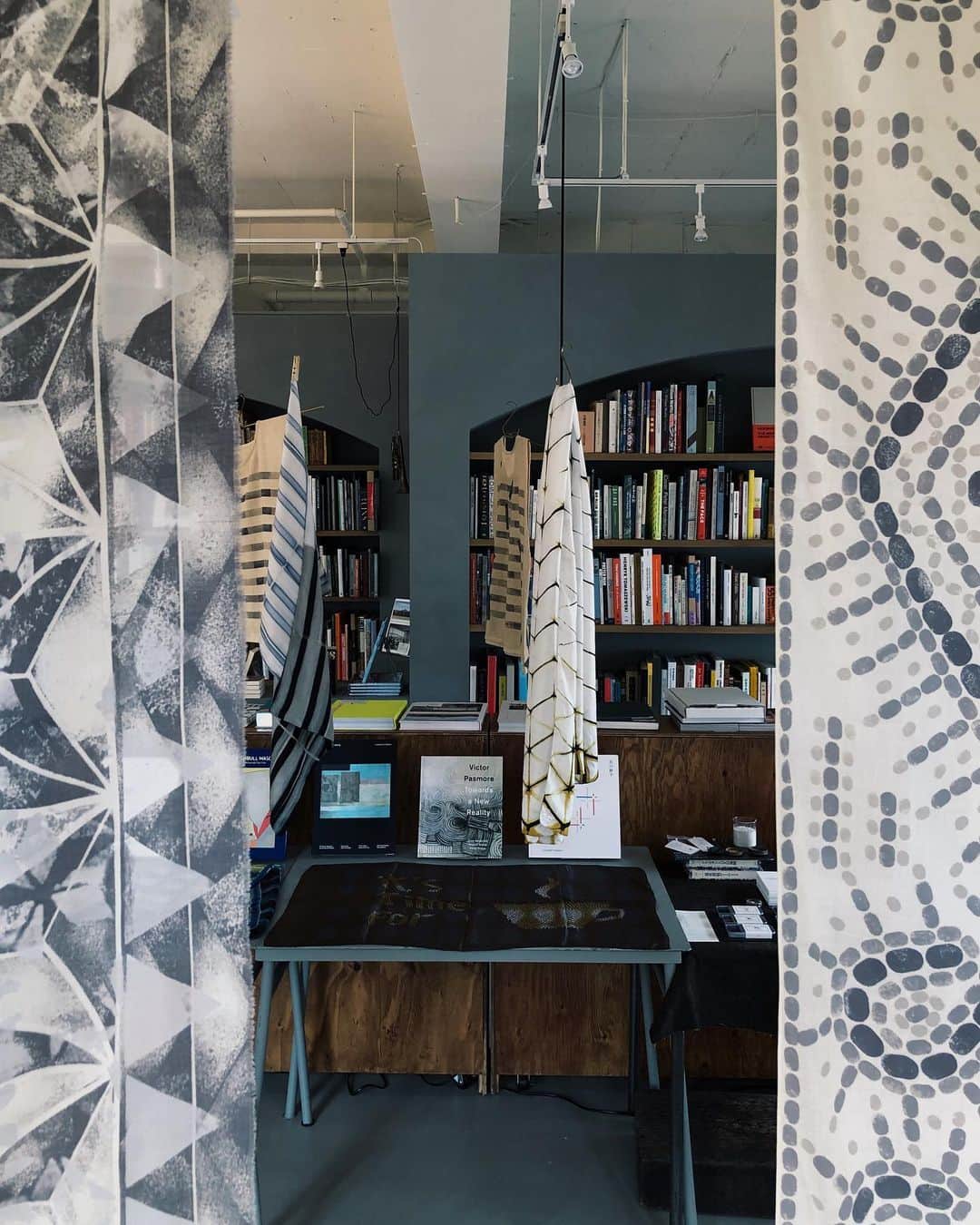 nostos booksのインスタグラム：「『SHIORI MUKAI TEXTILE / Block Mon Yoh』開催2日目となりました。  店内に吊られた向井さんのテキスタイルが初夏の風に揺られて、とても美しく涼しげ。  お買い求めいただいた展示作品はそのままお持ち帰りいただけます。すべて1点ものとなりますので気になる方はお早めに○  --------------------  向井詩織 @shiorimukaitextile インド西部カッチ県と滋賀の２拠点で、天然染料のブロックプリントをしている。カッチ県のブロックプリント工房は、本来ムスリムだけ、男だけの工房だが、テキスタイルアーティストとして単身で乗り込み、従来にないブロックプリントならではの模様を模索。日本では制作と展示活動を基盤に、ワークショップや講演などを行う。  --------------------  店舗情報はこちら @nostosbooks  --------------------  #向井詩織 #ブロックプリント #blockprint #nostosbooks #ノストスブックス #祖師ヶ谷大蔵 #砧」