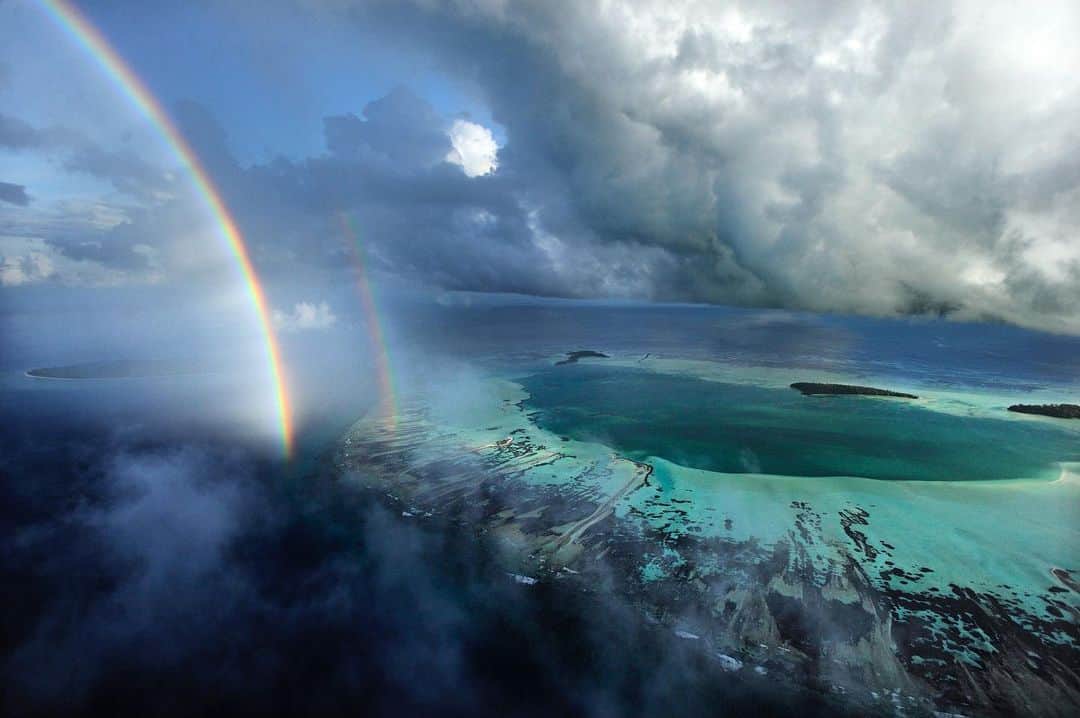 Thomas Peschakのインスタグラム：「I remember this flight like it was yesterday. Just as fuel was running low a second rainbow appeared in the channel between D’Arros Island and St. Joseph atoll. I only got one more pass to photograph before we had to land, but it was just enough time to capture this scene.  In March 2020 the waters around these two islands were declared the Seychelles newest marine protected area. The @saveourseasfoundation operates a research station on D’Arros and conducts science critical to the conservation of sharks, manta rays, turtles, reef fish and corals.」