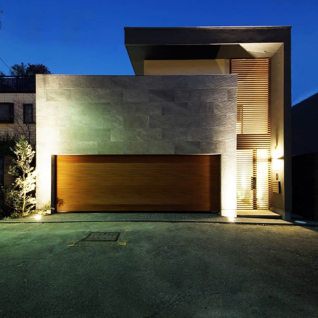 テラジマアーキテクツのインスタグラム：「箱を重ねたような外観デザイン。 木のルーバーやガレージドア、壁の石など質感のある素材を組み合わせて 昼も夜もそれぞれの美しい姿を楽しめます。  創業65年　東京・神奈川の設計事務所+工務店 @terajimaarchitects https://www.kenchikuka.co.jp/works/  #terajimaarchitects #テラジマアーキテクツ #設計事務所 #工務店 #注文住宅 #新築 #house #home #デザイン住宅 #建築実例 #luxuaryhome #beautifulhome #一戸建て #家づくり #建築家 #マイホーム #木造 #木の家 　 #モダンインテリア　 #おしゃれな家　 #心地よい家　 #家づくり計画中の人と繋がりたい 　 #マイホーム計画中の人と繋がりたい #シンプルモダン住宅 #家の外観 #外観デザイン」