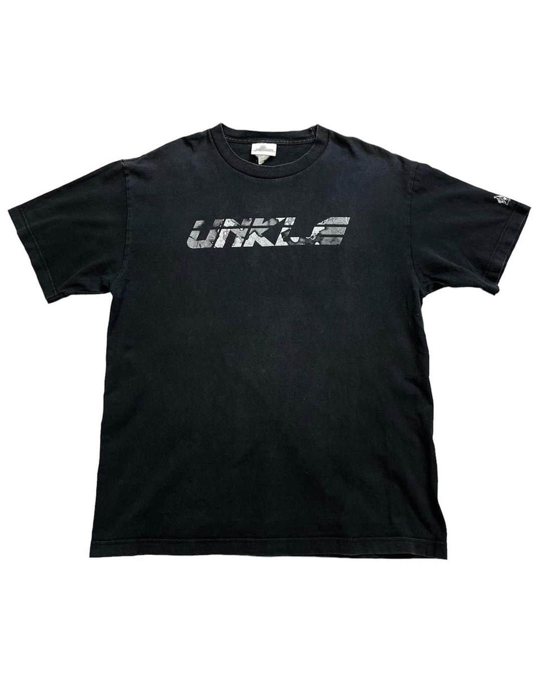 ジャムルのインスタグラム：「90-00's　UNKLE ¥21500+tax(23650) .  イギリスのDJ、プロデューサーであるジェームス・ラベル。 彼がなんと19歳の時に立ち上げたレーベルがMo'WAX！！ そして彼が中心となり1994年に結成した音楽プロジェクトがこのUNKLEです。  結成時から参加していたMAJOR FORCEの中西俊夫さんやK.U.D.O.さんに替わり 1998年にはDJ SHADOWが加入し1stアルバムをリリース、後にフジロックにも出演しました。  こちらはDJ SHADOWが参加した時期の大変希少な1枚です。  フロントにはグラフィック・アーティストのFUTURAが描いたUNKLEロゴ。 袖にはMo'WAXのロゴも入り、タグにはDJ SHADOWと豪華スペシャルな1枚です！！ . 海外でも非常に人気が高く、コアな音楽ファンには堪らないコレクタブルなTシャツ！ この機会に是非！！ .  WEB SHOPに入荷しております。 是非ご覧ください。 jammru.com  #お問い合わせはお電話で承ります #jammru#jammru_tee#vintagetshirt #vintagetee#vintagebandtee#unkle #djshadow #futura#mowax #osaka  #fashion  #streetstyle  #streetfashion  #vtg  #vintage  #used  #usedclothing  #古着 #古着屋 #ファッション #70s #80s #90s」