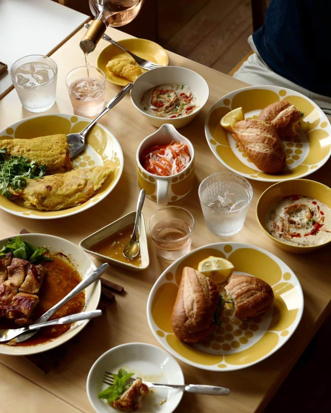 Scopeさんのインスタグラム写真 - (ScopeInstagram)「週末はベトナム料理にて #スンヌンタイのブランチ しましたから長いんだけど 感じた諸々を書いてみます。  僕は料理を盛り付ける前に どの料理をどの食器に盛り付けるか？ 食器をテーブルに並べてみることから 始めます。食器を入れ替えつつ、 そのセットが完成するまで組み替え、 入れ替えを続け、今回はコレでいく！ それが最後の写真です。  スンヌンタイに Teemaホワイト＆ハニーを混ぜると イイ感じにまとまりますし、夏は Teemaホワイト＆ハニーが映えます。 そしてツンドラのクリアなツブツブ 装飾がスンヌンタイとマッチして 想像以上によかった！ナイスと思う！ だからウォーターグラスに Tundraタンブラー 290ml クリアを 選び、バランスをとってワインは Bellman ウィスキーにしましたら 使うにも良いバランスでした。  バインミーは名古屋に新しくできた @banhmixinchao.jp で買ってきて 置いただけながら、オーバルプレート 25cmと、バインミーの形状はなんだか マッチして可愛らしかった。嚙む力も 鍛えられアゴ筋トレにもなって衰えを 少し克服した気分です。そのサイドに Teemaシリアルボウルとプレート15cm のハニー＆ホワイトを添えてます。 この組み合わせは安定配置です。  センターにはバインセオを盛り付けた Sununtai プレート26cm、そのタレは Teemaミニサービングセットリネンの 三角型に入れたのが超良かった。 そしてスタッフ松尾が激押ししている Savoniaケーキリフター、そこまで 大きくなくて見た目のバランスもよく 取り分けに使うと便利からのナイス。 1つあるといいのは確かです。  ガイヤーン＆ミントは Teemaプレート23㎝リネン を使いました。  今回リネンは2つ加えていますが、 あまり増やすと夏感が薄れるので 少しだけ足すのが良いみたい。  ただ午前中から飲んで調子でると 午後から寝てしまって気づけば夕方 オーマイゴッドファーザー降臨！ となりますのでご注意を。 でも、とても美味しかったです。  何かしらの参考になればとツラツラ 書いてみまスタミナ弁当。  #scope_japan #スコープ計画018 #スンヌンタイのブランチ #arabiafinland #sunnuntai #スンヌンタイ #iittala #イッタラ #teema #ティーマ #北欧食器 #北欧雑貨 #tundra #ツンドラ #ベトナム料理 #バインミー #バインセオ #ガイヤーン #アラビア食器 #ブランチ」6月26日 15時44分 - scope_japan