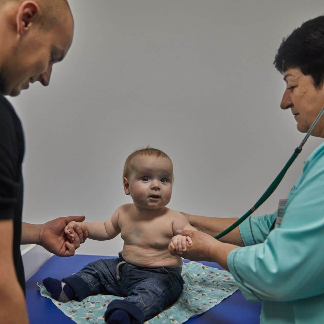unicefのインスタグラム：「Baby Oleksandr is getting his childhood vaccines thanks to his father Maksym and a UNICEF-supported health worker in Ukraine.  “I am very positive about vaccination,” says Maksym. “War is no reason to neglect children's health.”  As families deal with adversity, UNICEF supports the continuation of health services across the country with critical medical and immunization supplies.  © UNICEF/Khomenko」